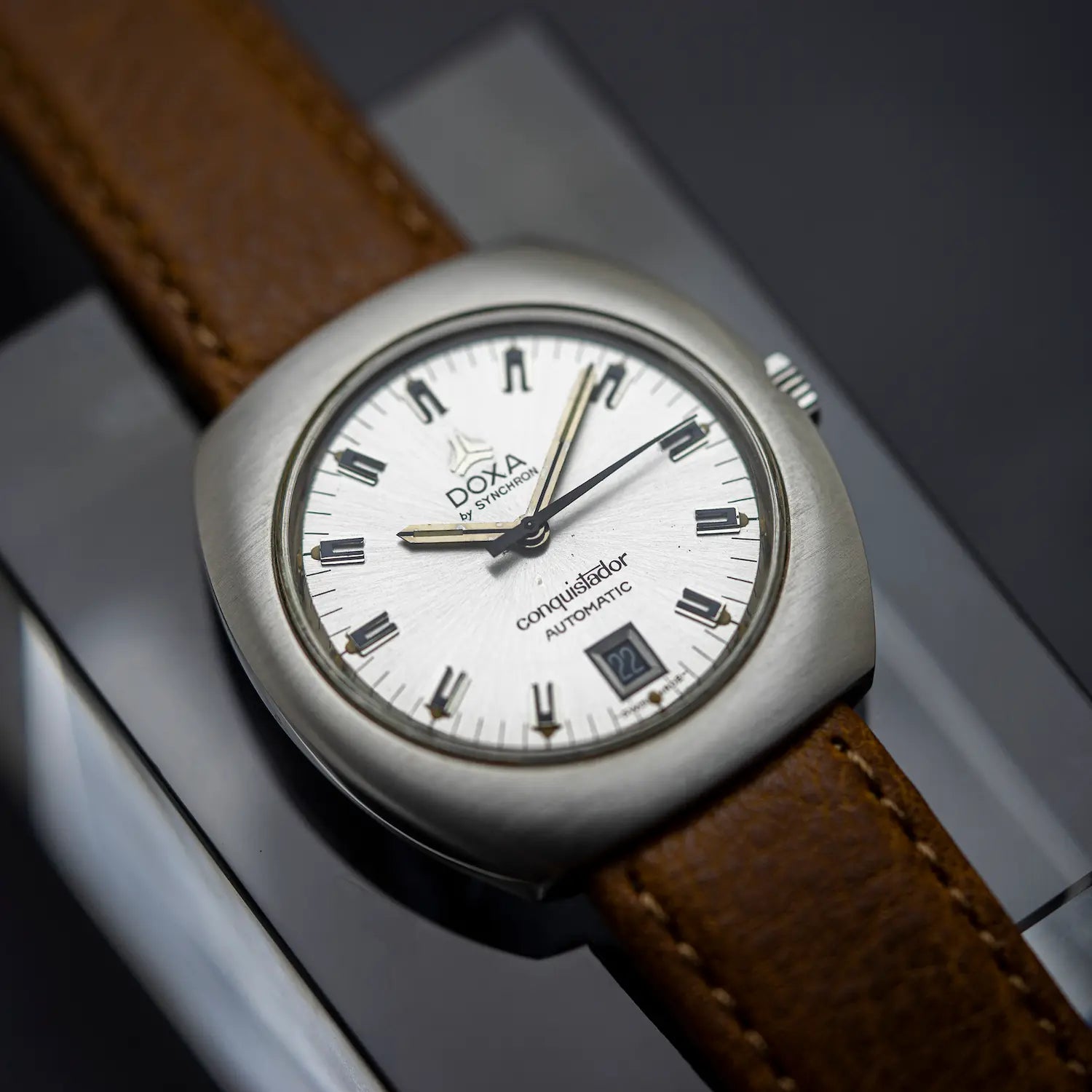 Doxa vintage watch with silver dial and re leather strap on glass background