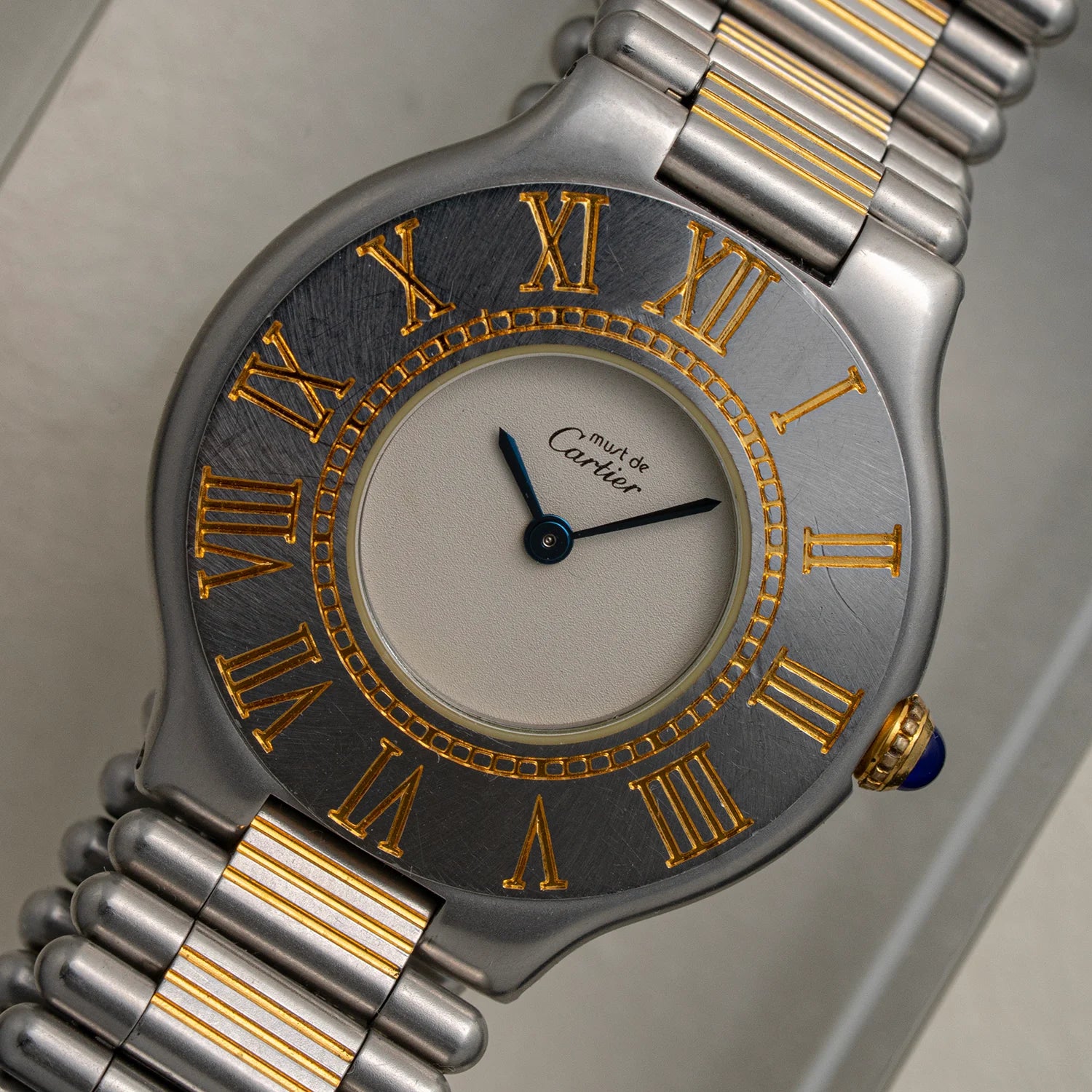 Cartier Must De Cartier 21, Ref. 9010, Cal. 81, 1989 watch with silver and gold band and Roman numeral markers on a neutral background