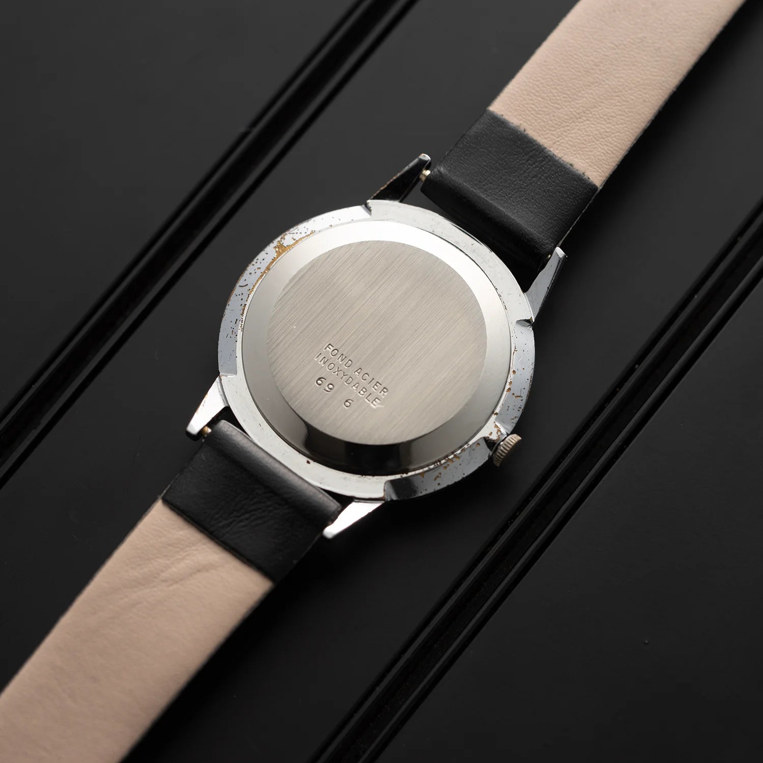 Caseback of Gruen Precision vintage men’s dress watch with black leather strap and brushed steel back