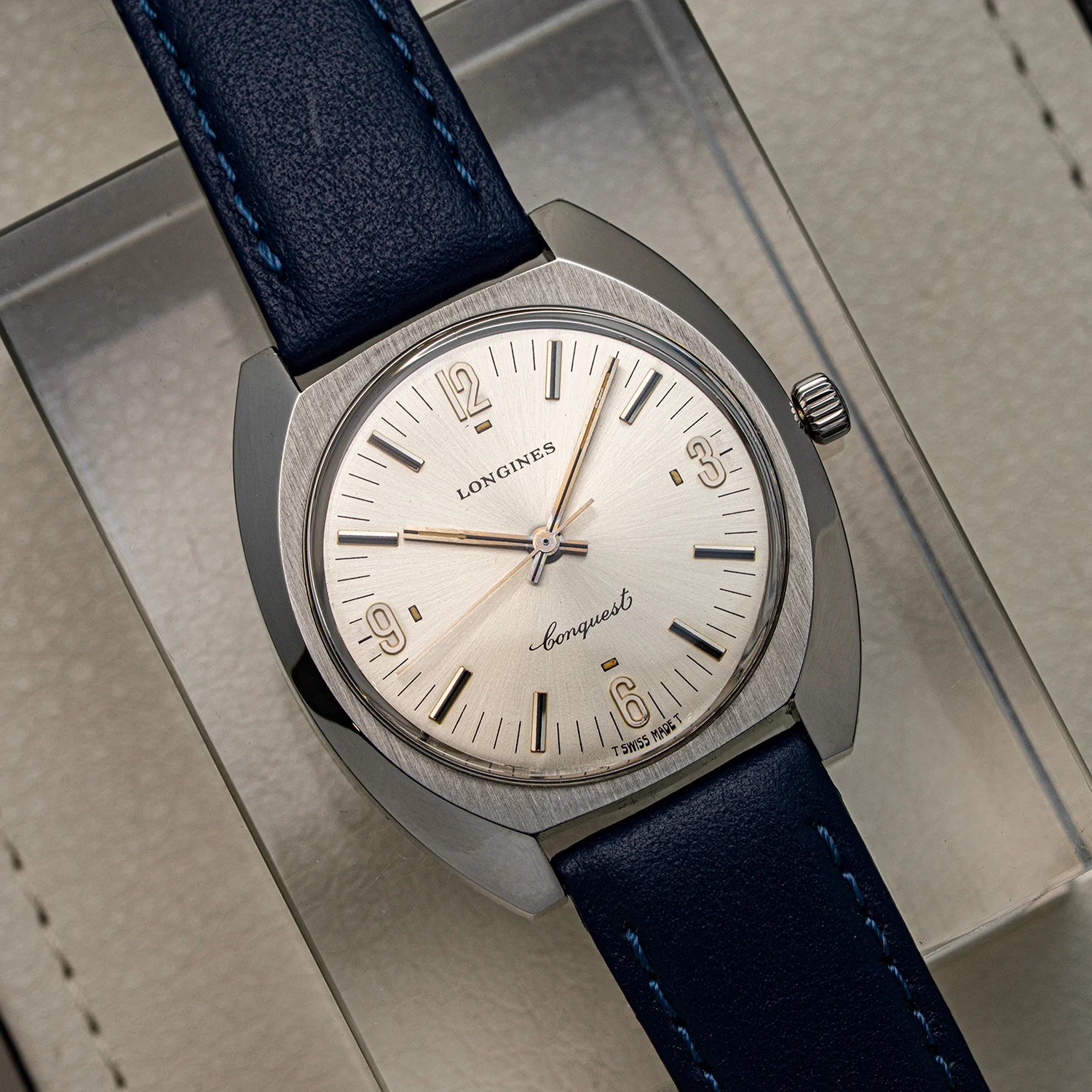Longines watch with blue leather strap on a textured surface