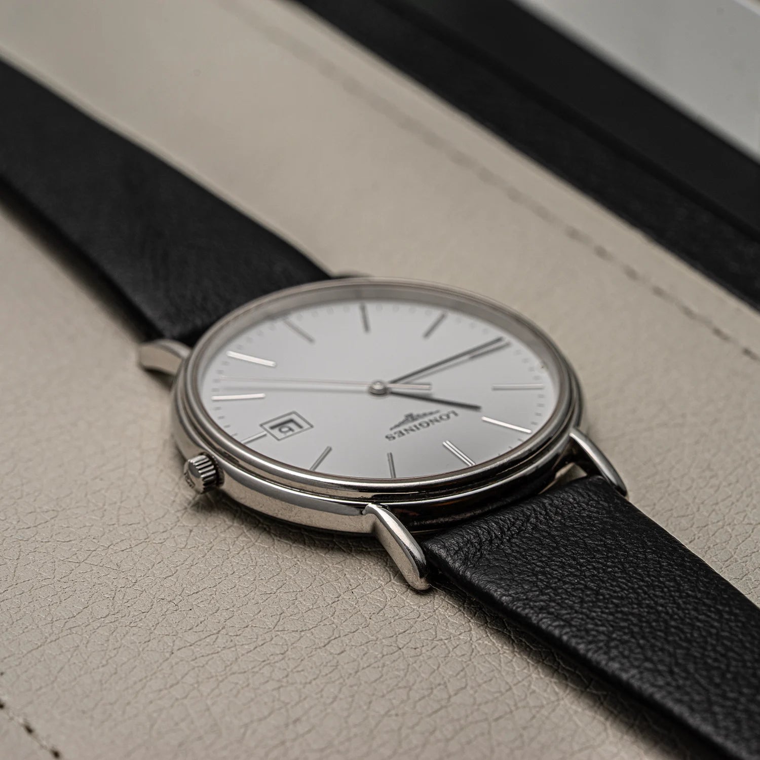 Wristwatch Longines Presence, Ref. L4.790.4, Cal. L157.2, 2018 with black strap on a textured surface