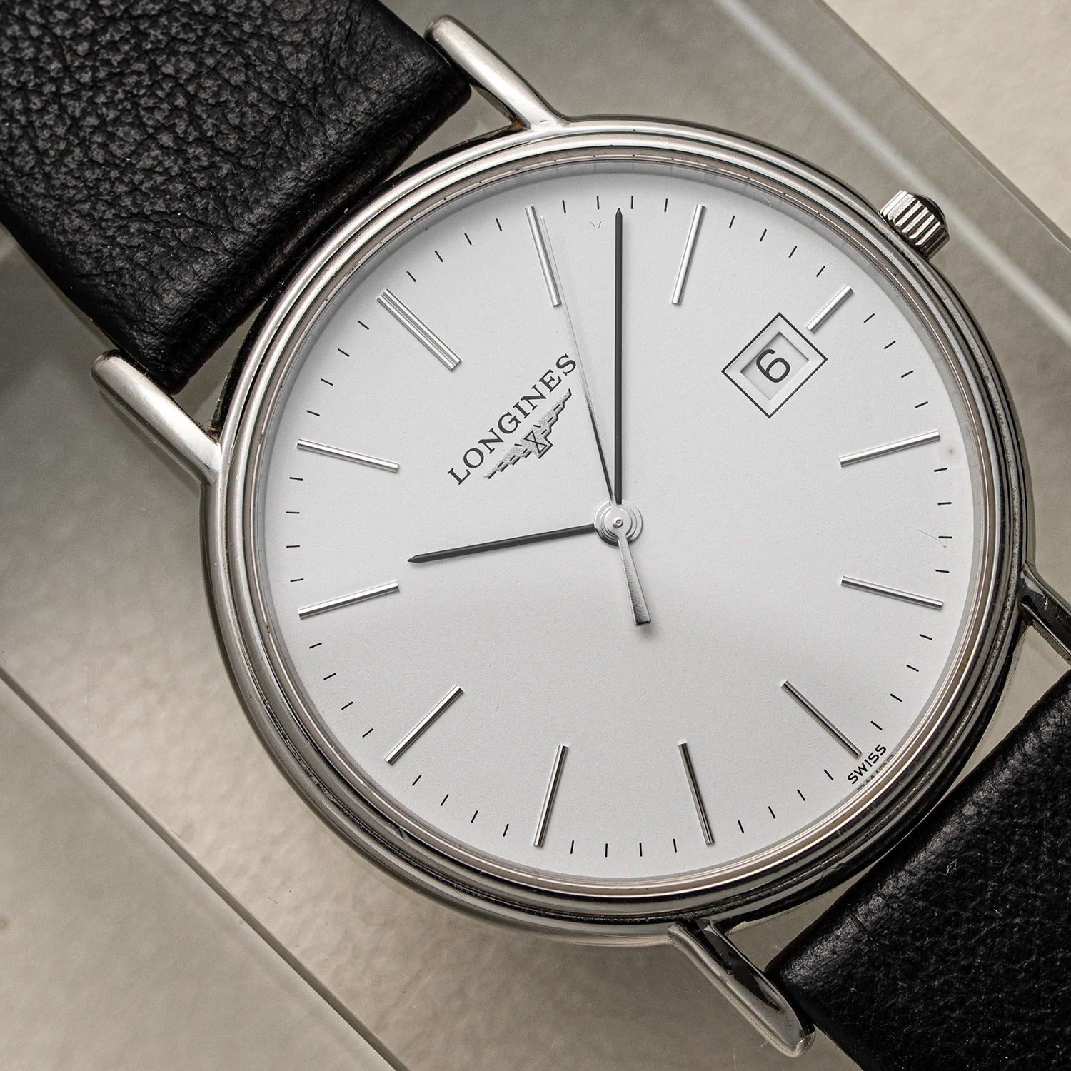 Longines Presence, Ref. L4.790.4, Cal. L157.2, 2018 watch with black leather strap on a light gray surface