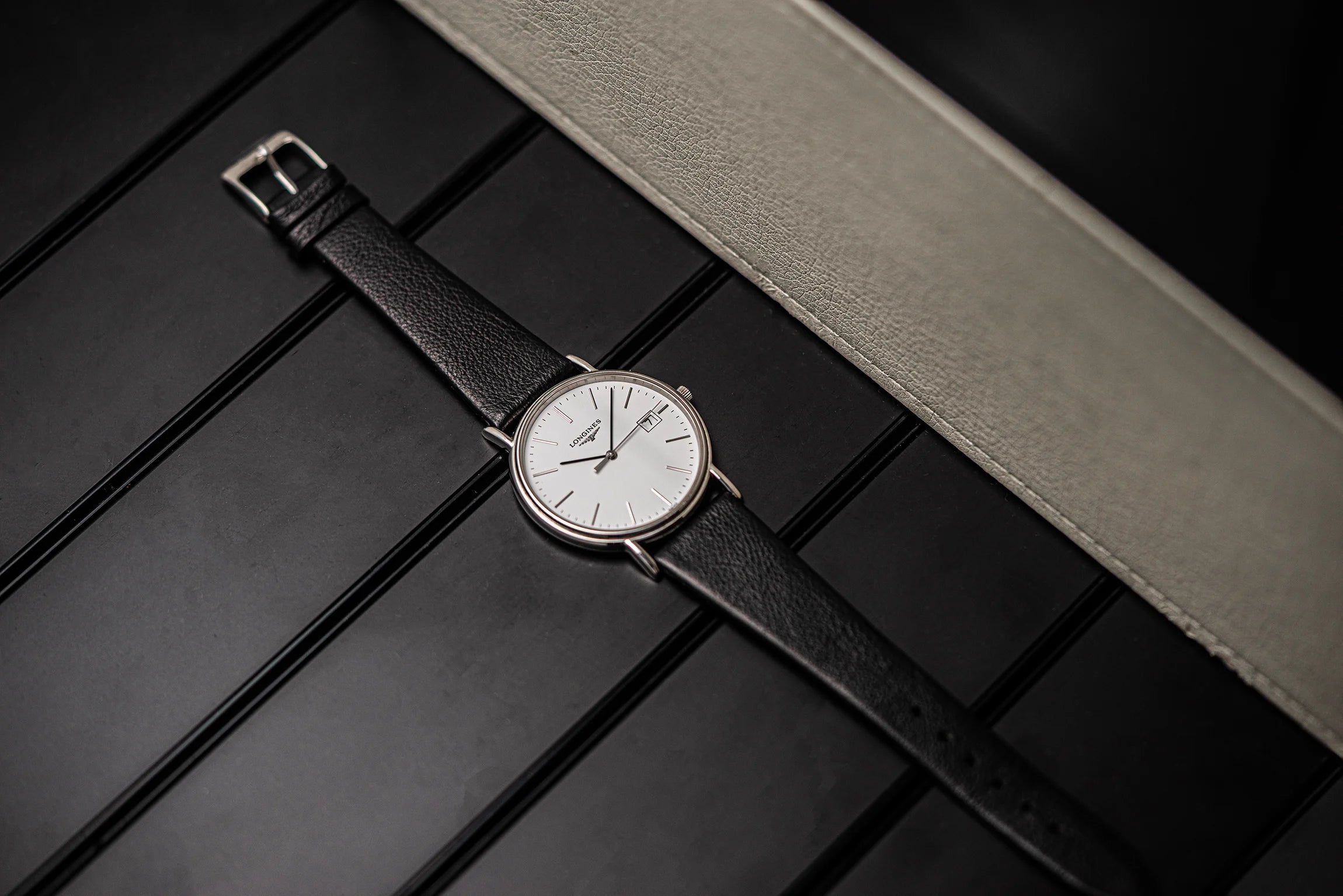 Longines Presence, Ref. L4.790.4, Cal. L157.2, 2018 wristwatch with a white face on a dark wooden surface