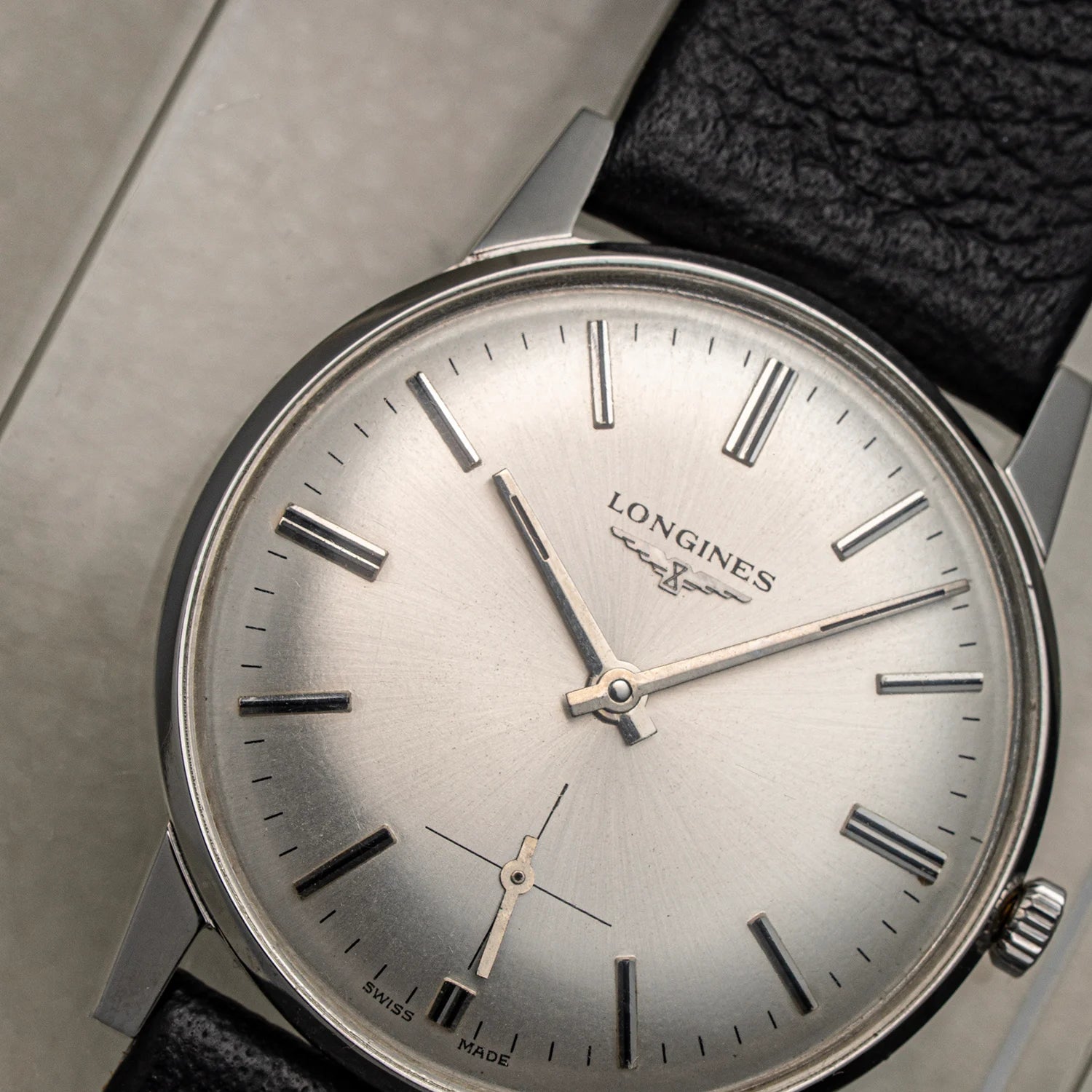 Longines, Ref. 1016, Cal. 6922, Men’s Dress Watch, 1969 watch with silver dial and black strap on a neutral background