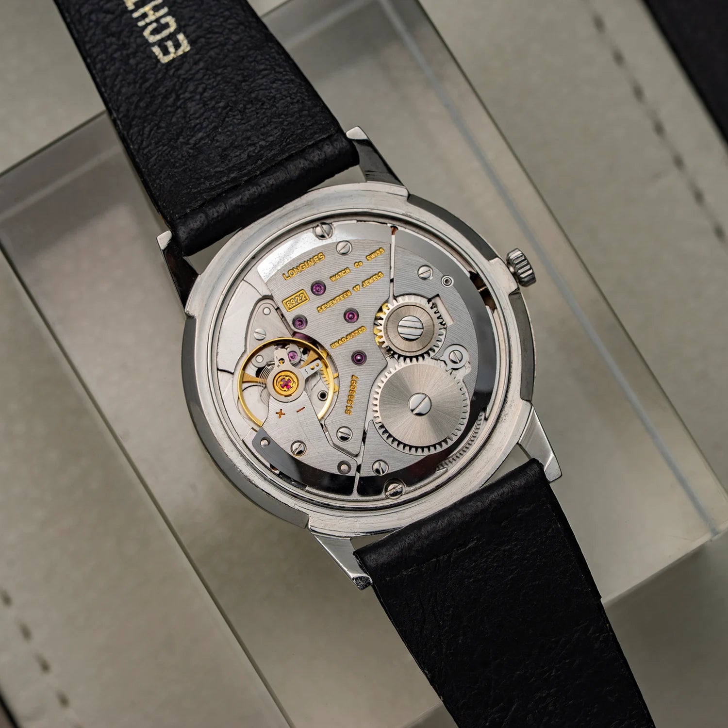 Longines, Ref. 1016, Cal. 6922, Men’s Dress Watch, 1969 with black strap and visible mechanical components on a gray surface