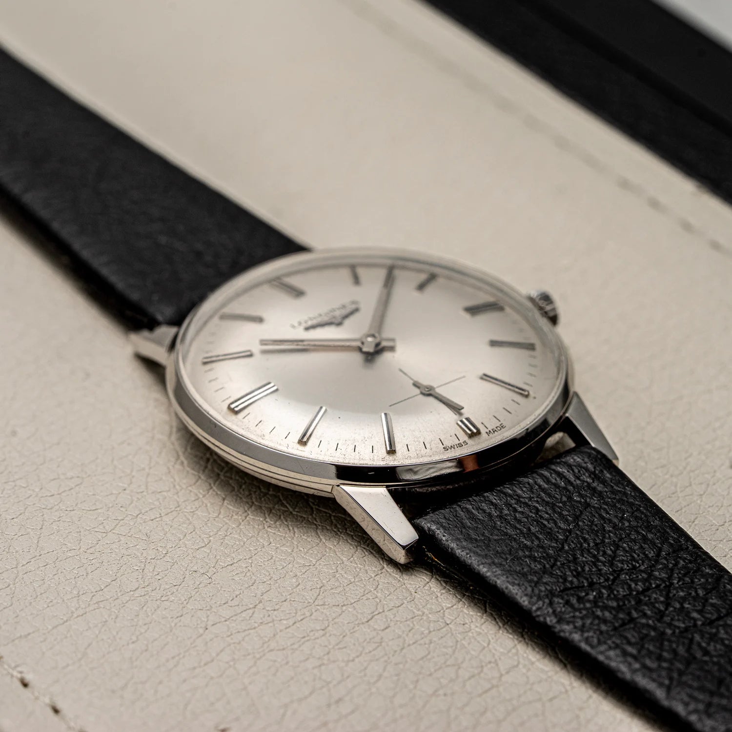 Wristwatch Longines, Ref. 1016, Cal. 6922, Men’s Dress Watch, 1969 with black strap on a light gray surface