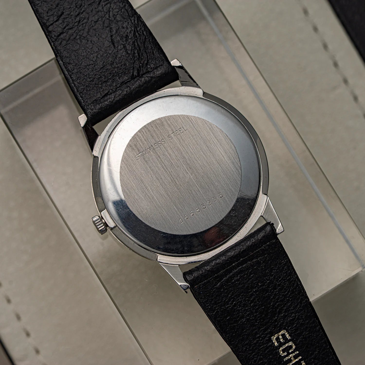 Wristwatch Longines, Ref. 1016, Cal. 6922, Men’s Dress Watch, 1969 with black leather strap and silver case on a reflective surface