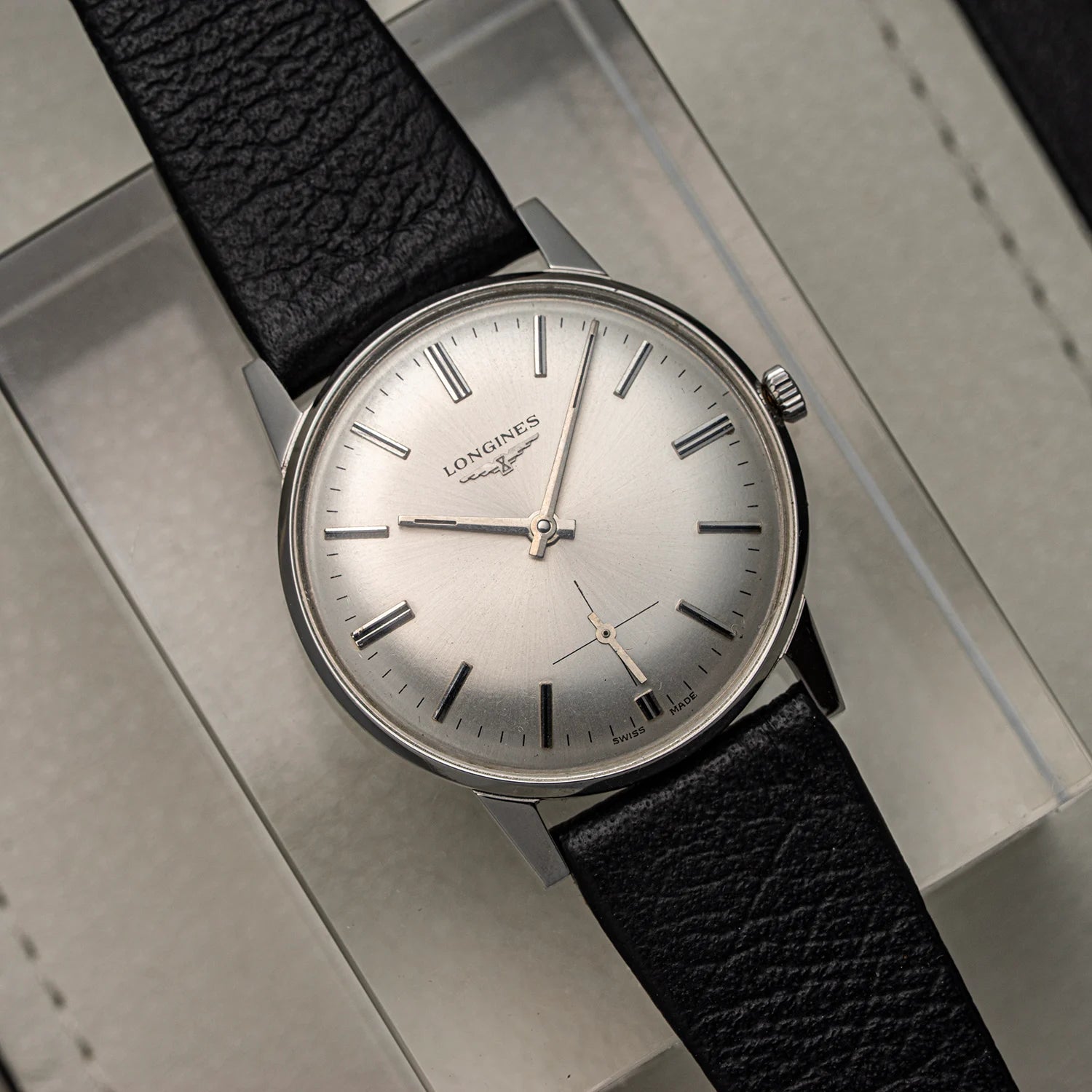 Longines, Ref. 1016, Cal. 6922, Men’s Dress Watch, 1969 watch with black leather strap on a metallic surface
