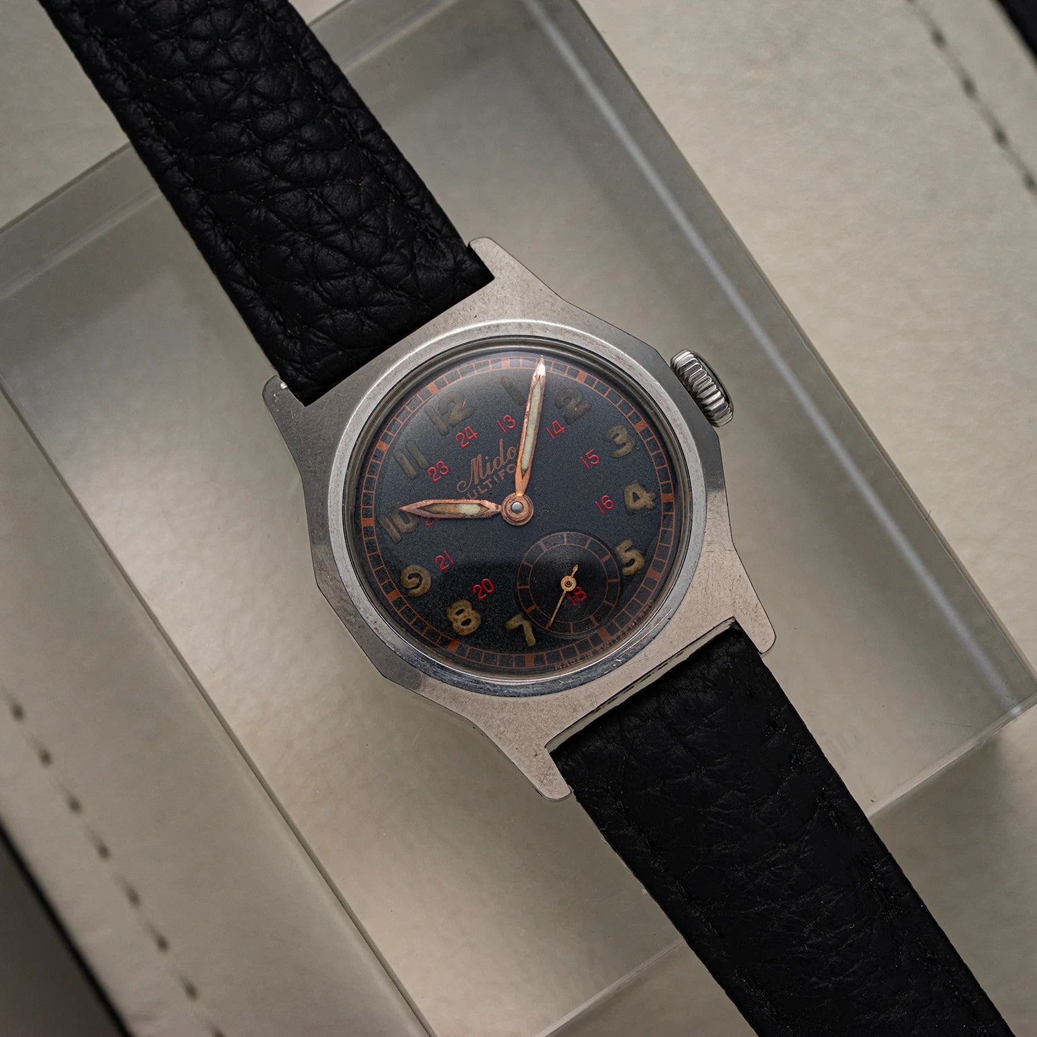 Mido Multifort Limited, Men’s Vintage Military Watch, 1940 with black strap on a textured surface