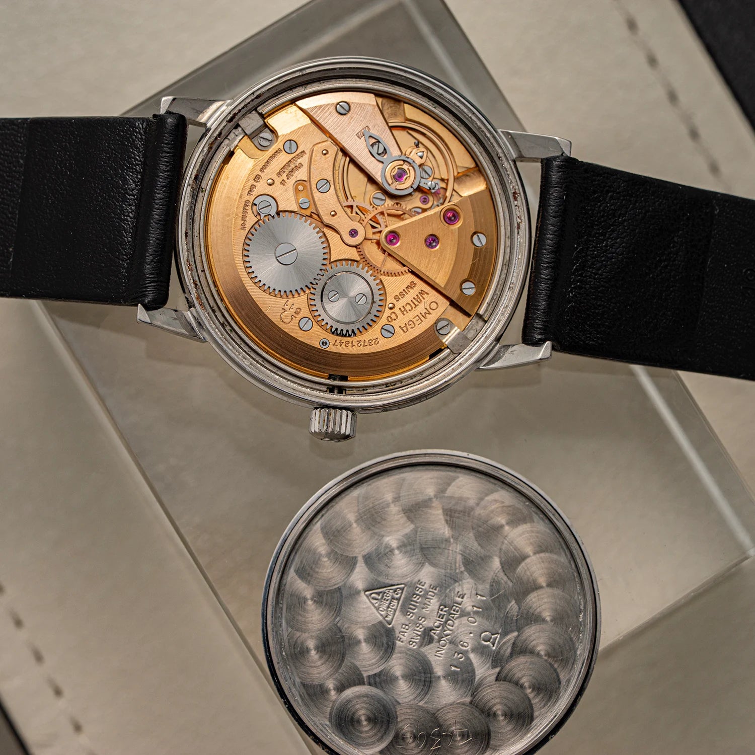 Close-up of a mechanical watch Omega Seamaster 600, Ref. 136.011, Cal. 611, 1966 with black leather strap on a reflective surface