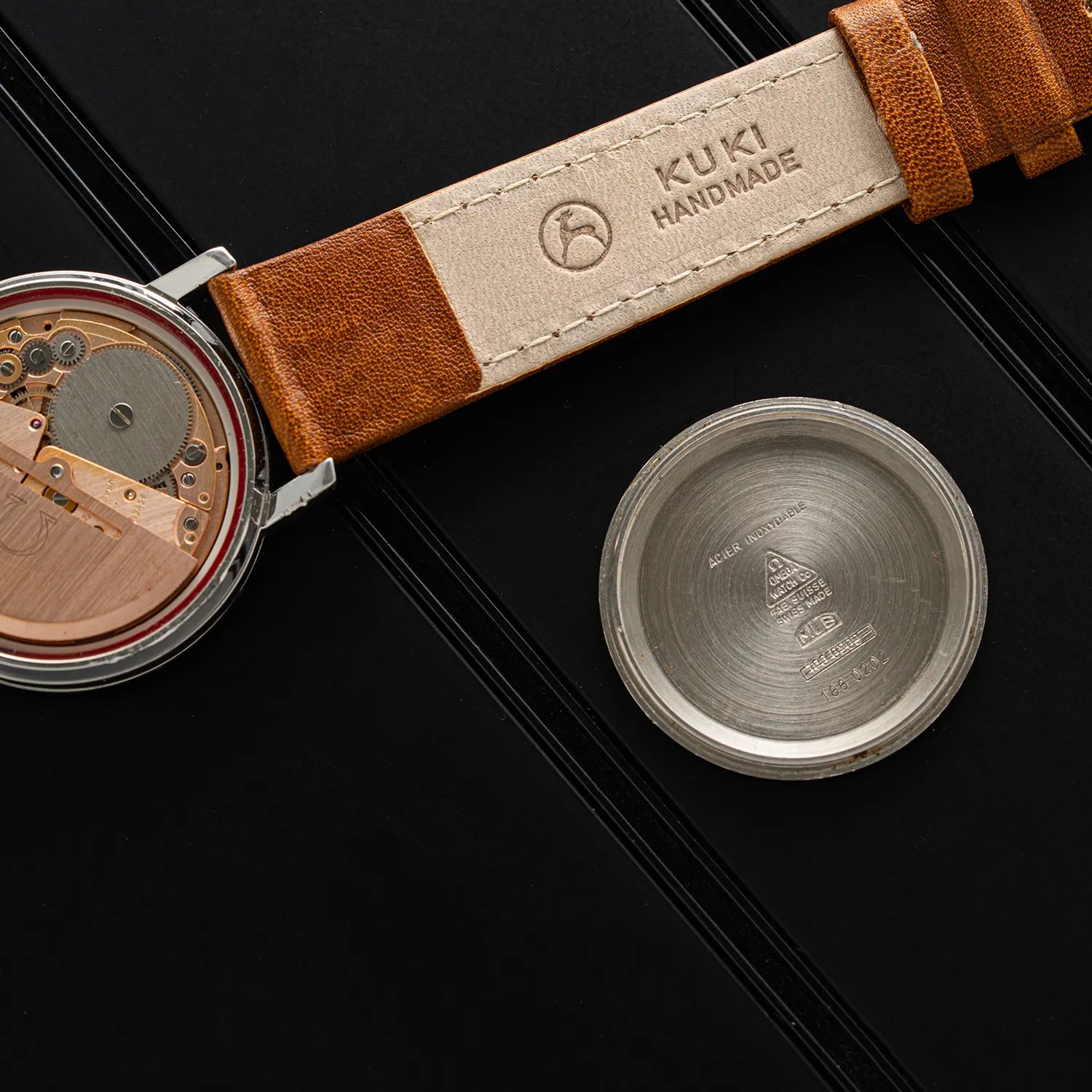 Omega 166.0202, Cal. 552 with brown leather strap and visible brand name on a black background