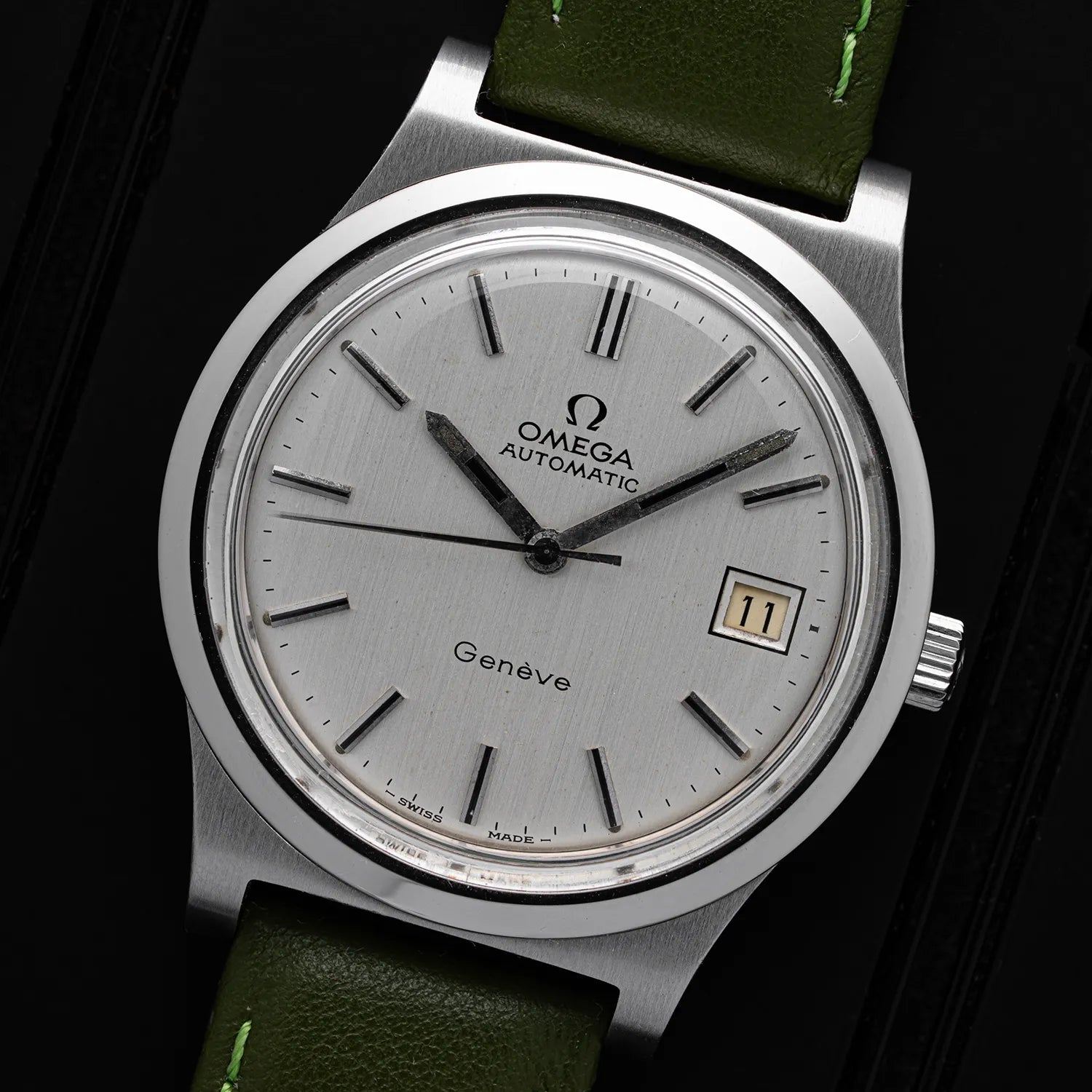 Omega Genève, Ref. 166.0168, Cal. 1012 watch with green strap on a dark background