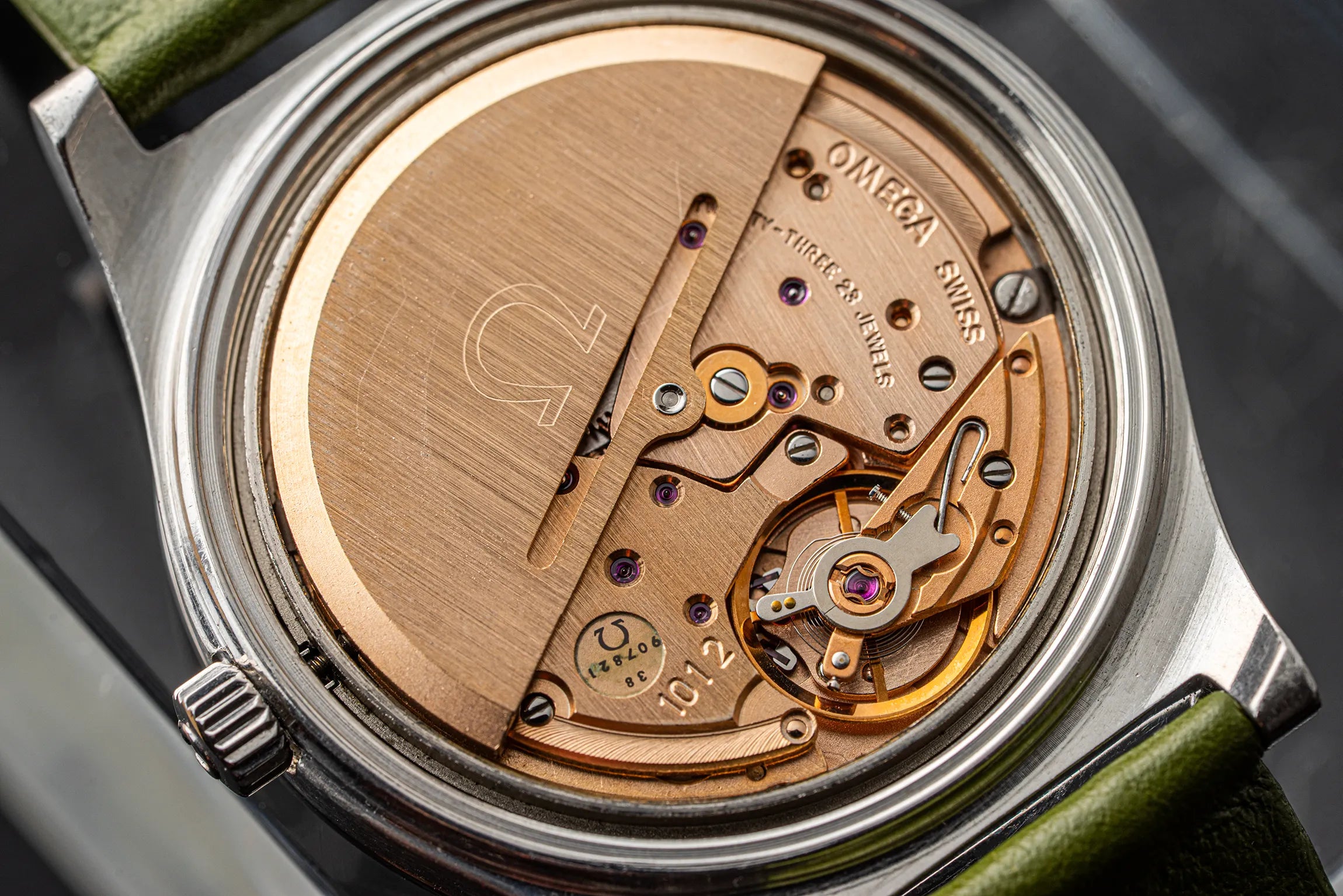 Close-up of a watch mechanism with Omega branding on a dark background