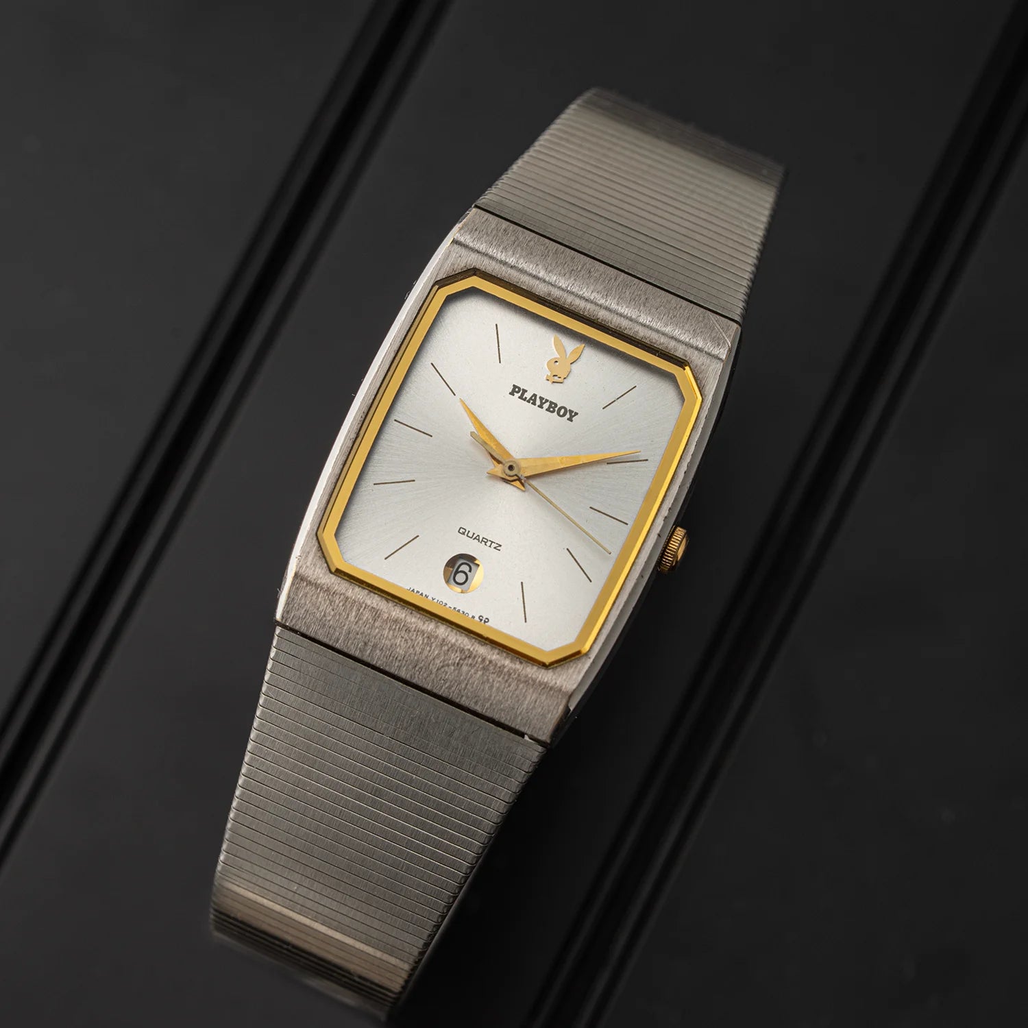 Detailed angle of Seiko Playboy quartz watch showing geometric gold-tone inner frame, silver dial, and integrated bracelet