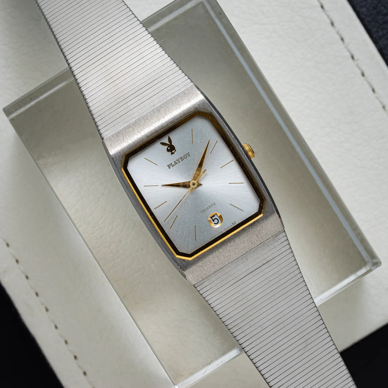 Seiko Playboy vintage men’s quartz watch from 1985 with silver sunburst dial, gold-tone accents, integrated metal bracelet, and date at 6 o’clock, top view