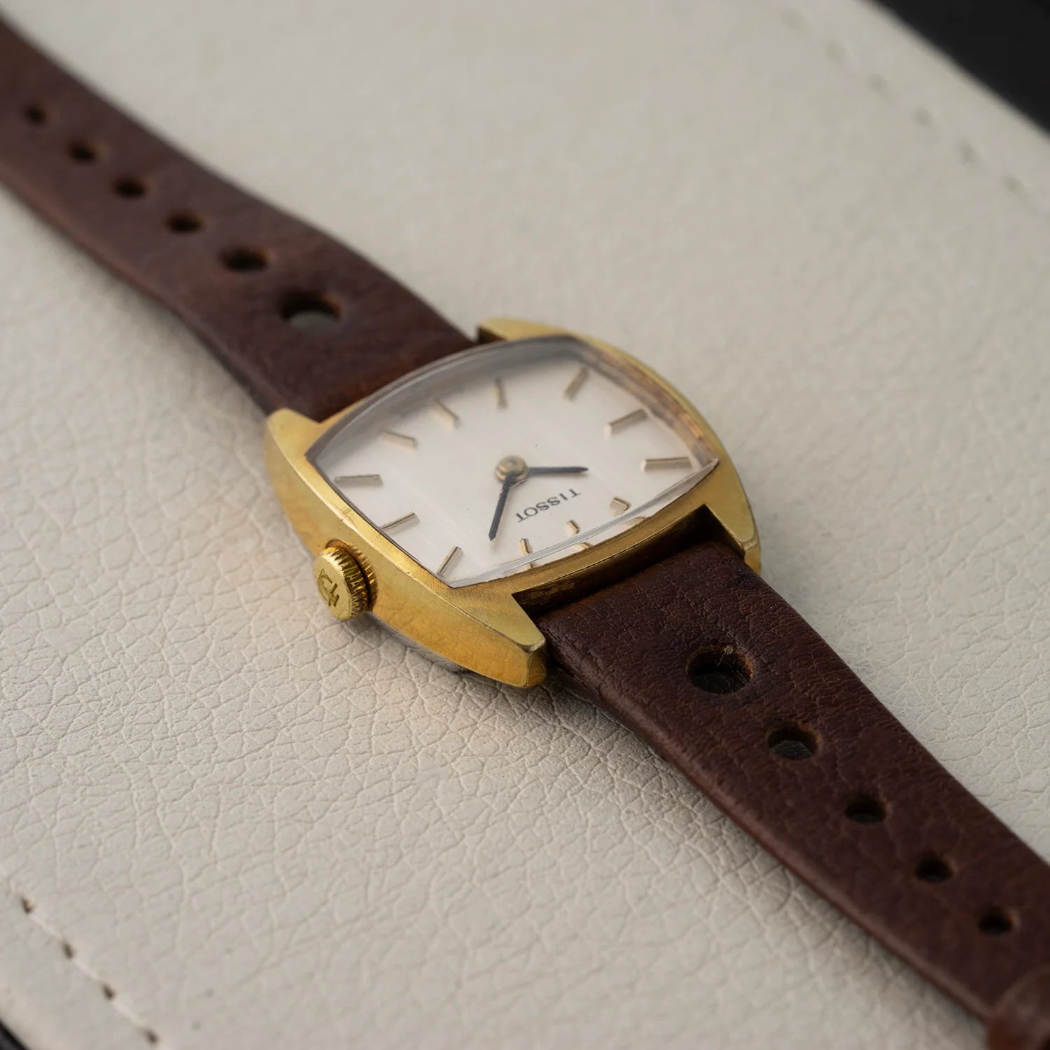 Tissot women’s vintage dress watch with gold plated case, silver dial, and brown leather strap, full-watch top view