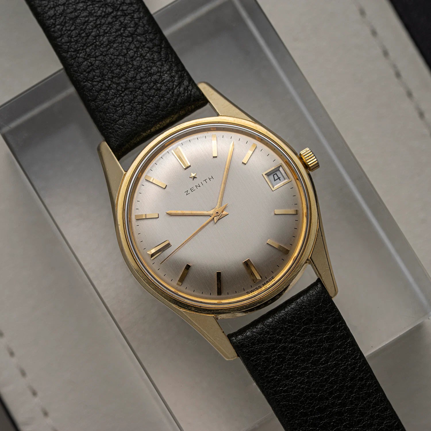 Zenith Zenith, Cal. 2532C, Men’s Manual Wind Vintage Watch, 1966 with black strap and gold casing on a gray background