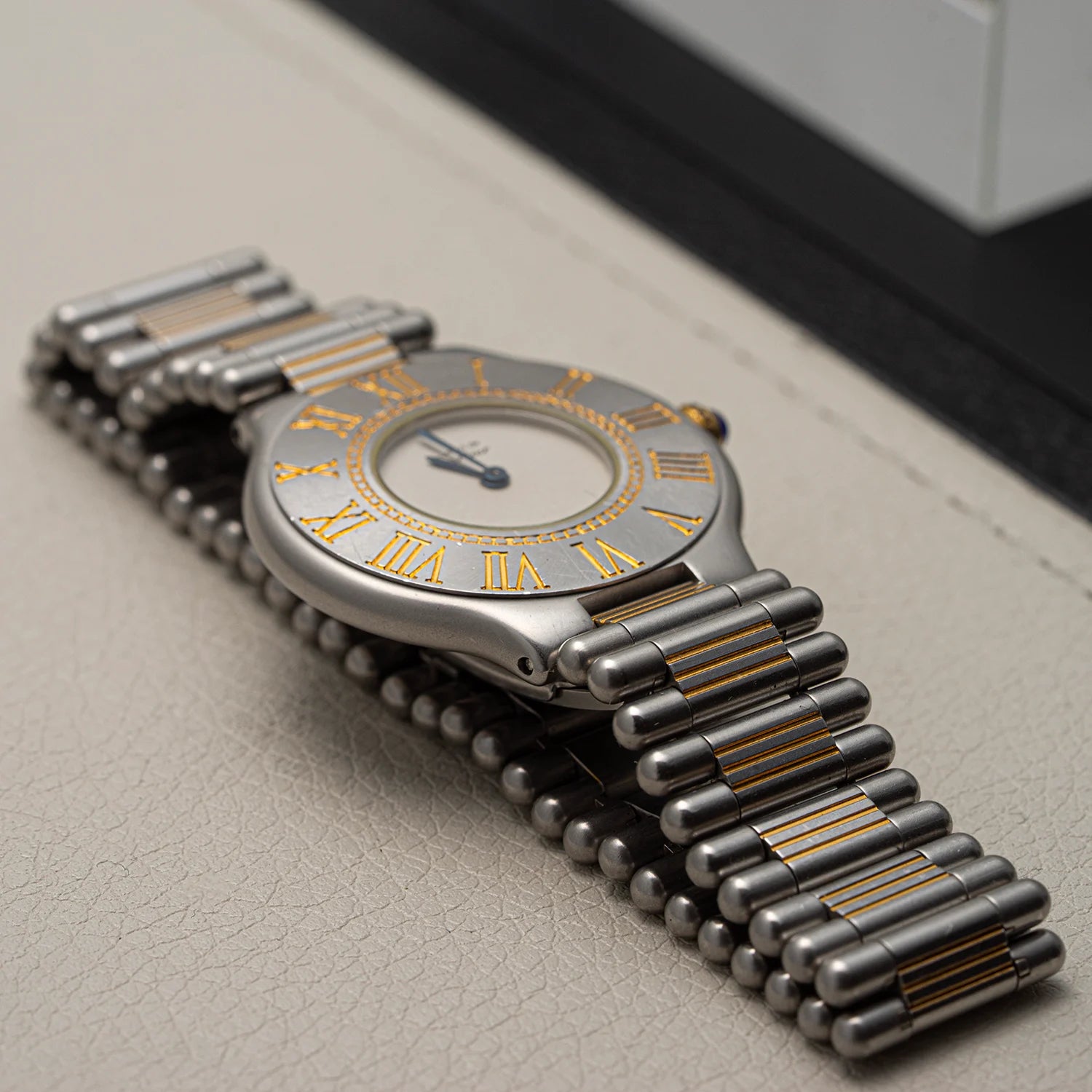 Luxury Cartier Must De Cartier 21, Ref. 9010, Cal. 81, 1989 with metallic band on a textured surface