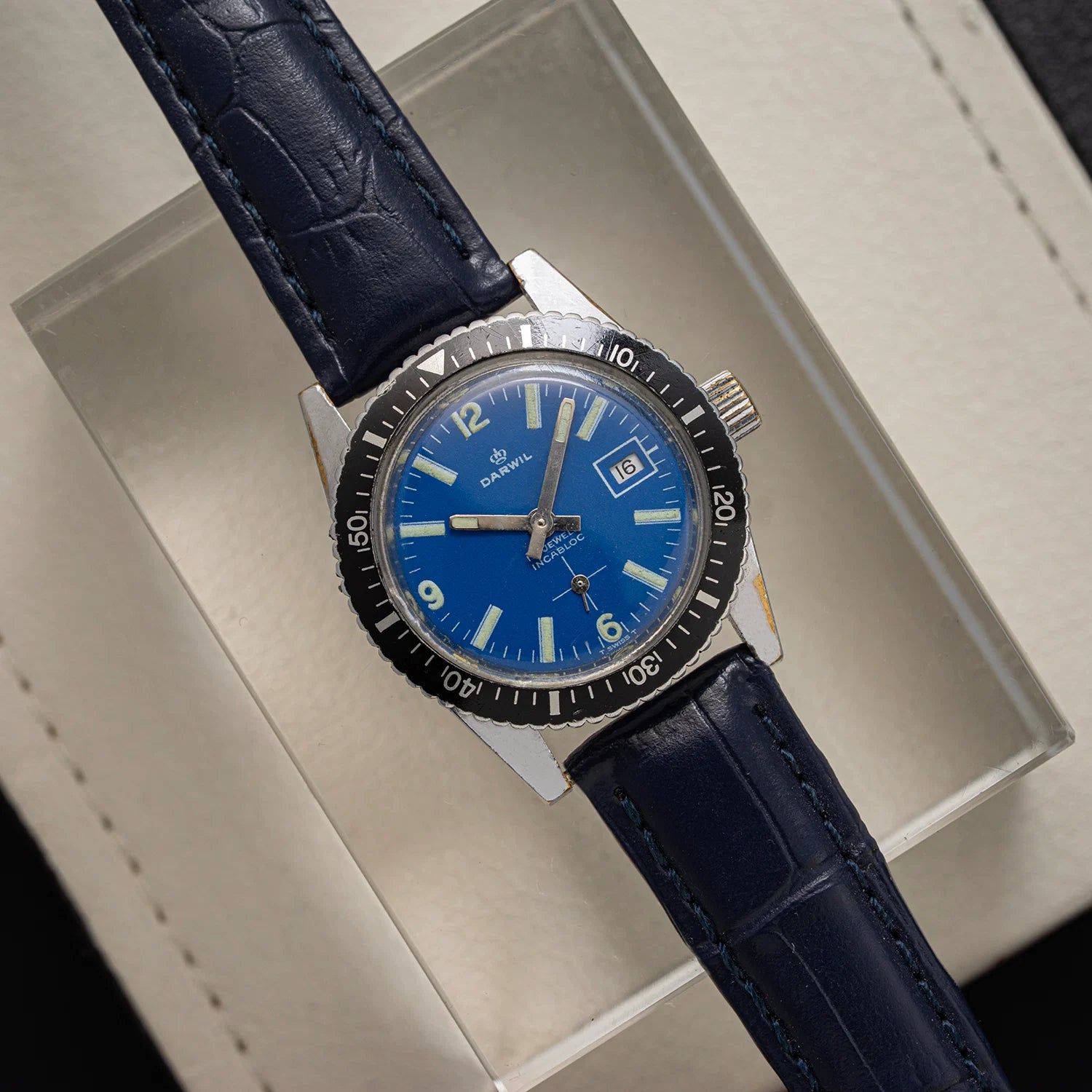 Wristwatch Darwil Diver, Ref. 8522, Cal. 7012, Women’s Manual Wind, 1971 with blue dial and dark blue leather strap on a light gray background