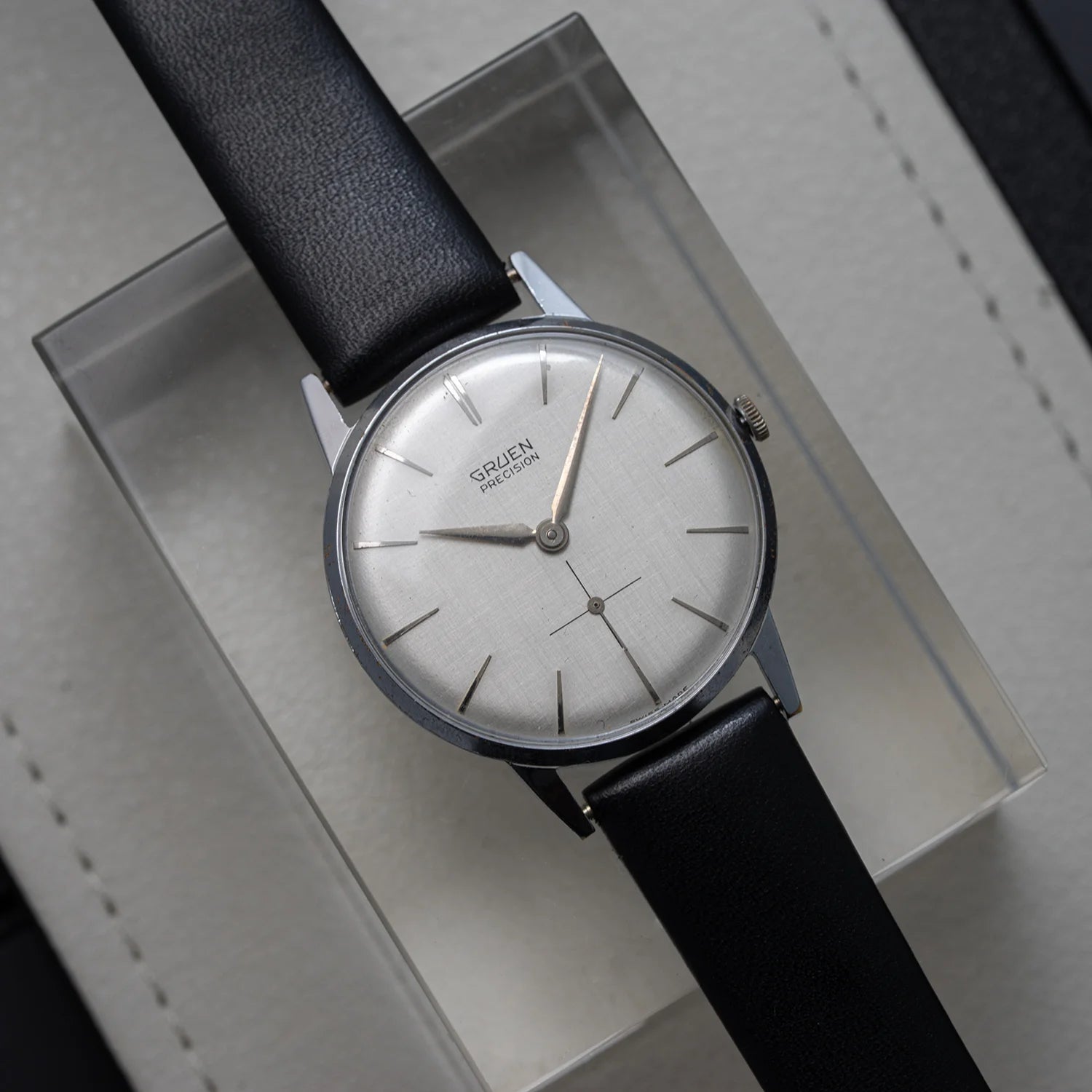 Gruen Precision vintage men’s dress watch from 1952 with silver dial, small seconds, and black leather strap, top view
