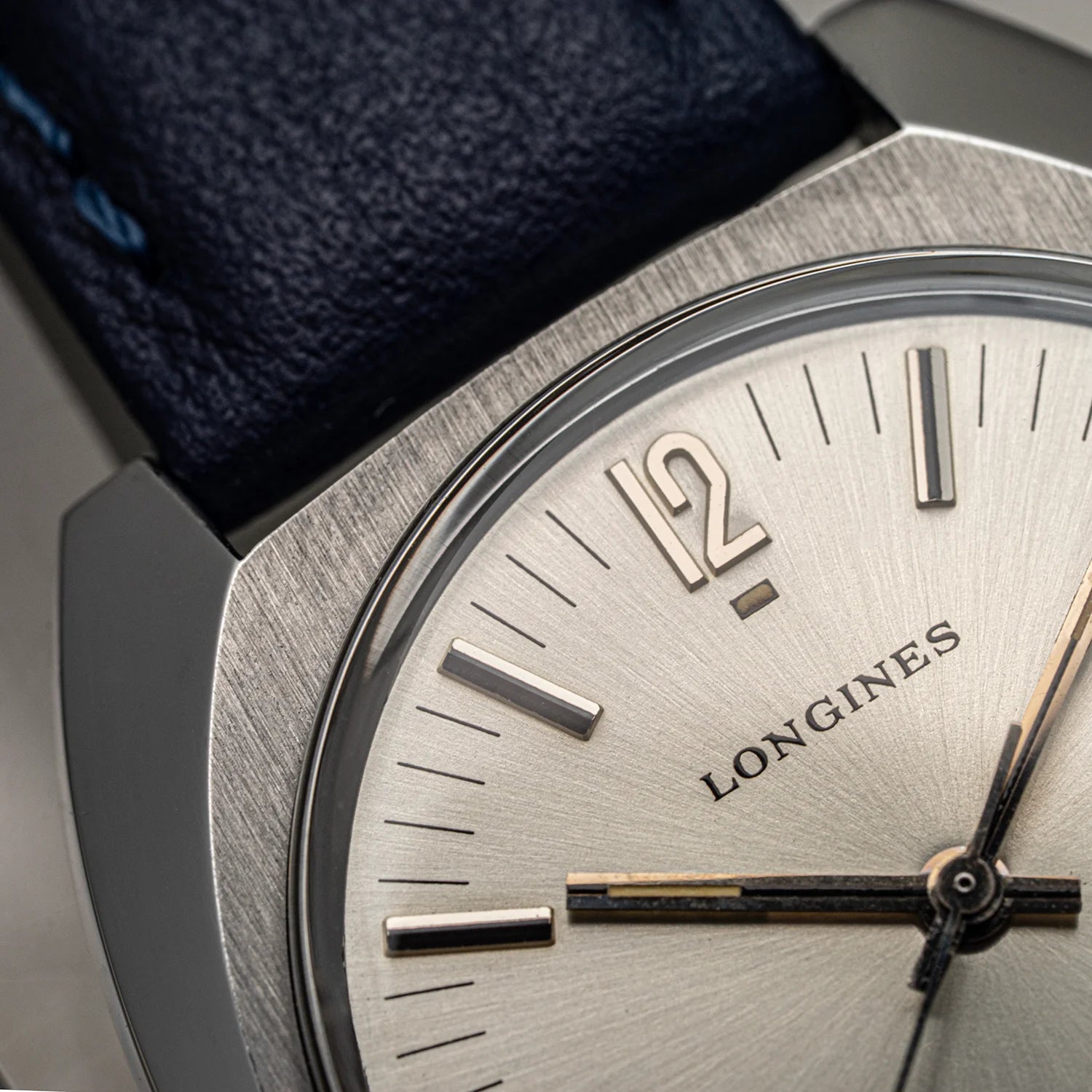 Close-up of a Longines watch with a blue strap and silver case.