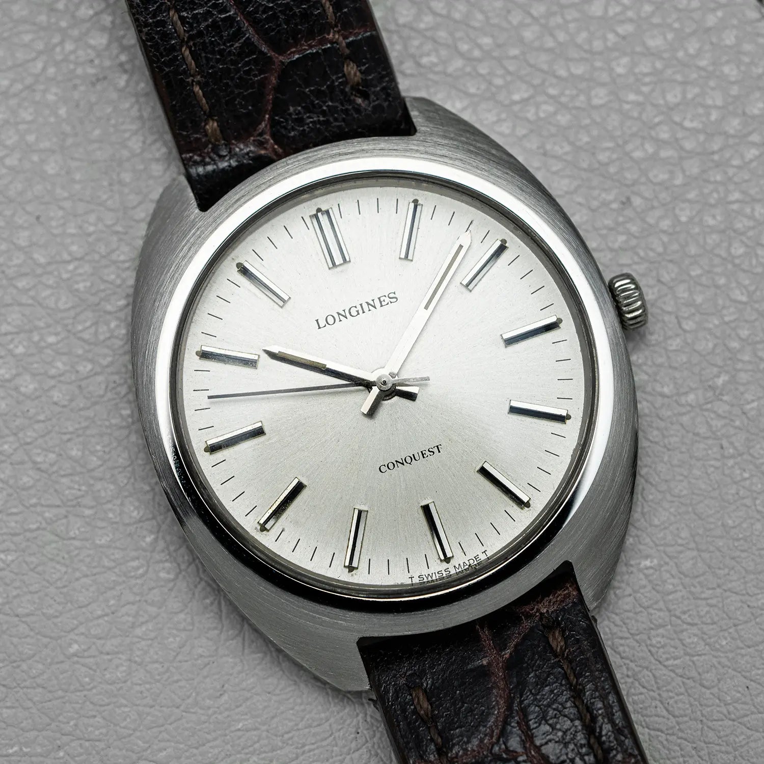 Longines Conquest Ref 1500 Cal 706 watch with brown leather strap on a gray textured background