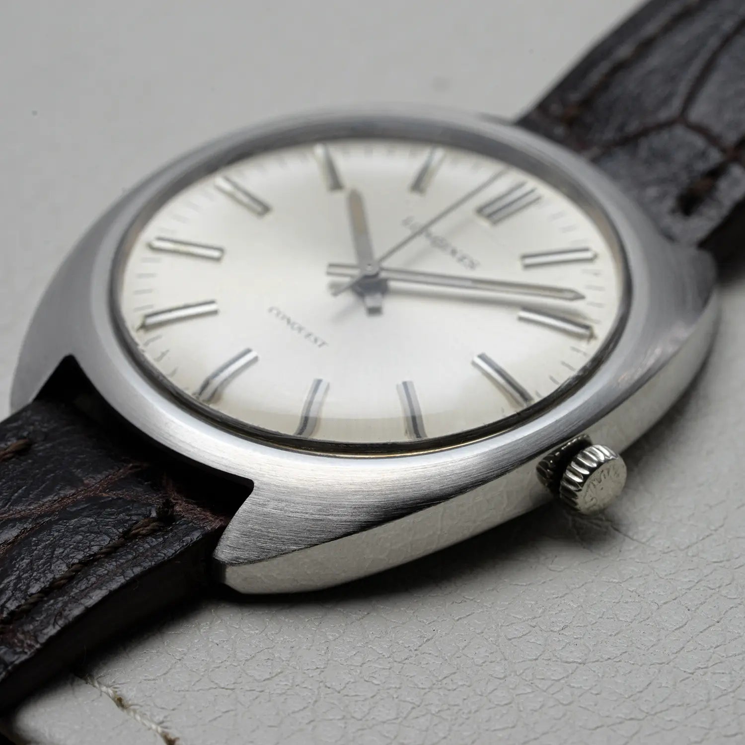 Vintage Longines Conquest Ref 1500 Cal 706 watch with a brown leather strap on a light gray surface
