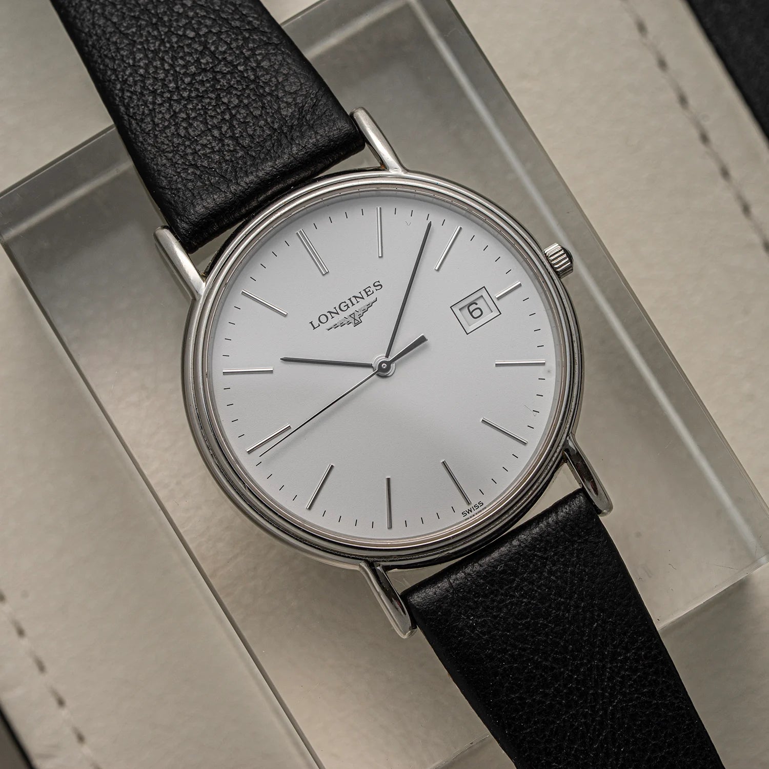 Longines Presence, Ref. L4.790.4, Cal. L157.2, 2018 watch with black leather strap on a reflective surface