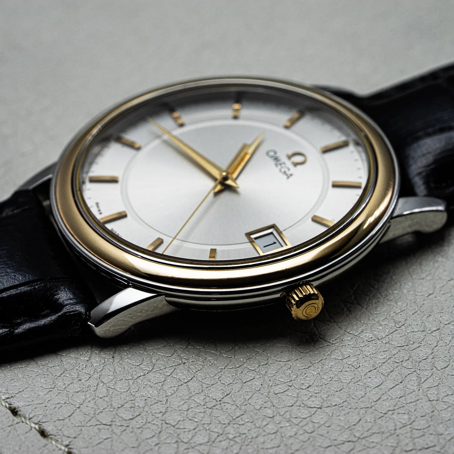 Omega De Ville Prestige, Ref. 196.1150 Crown with on a gray textured surface