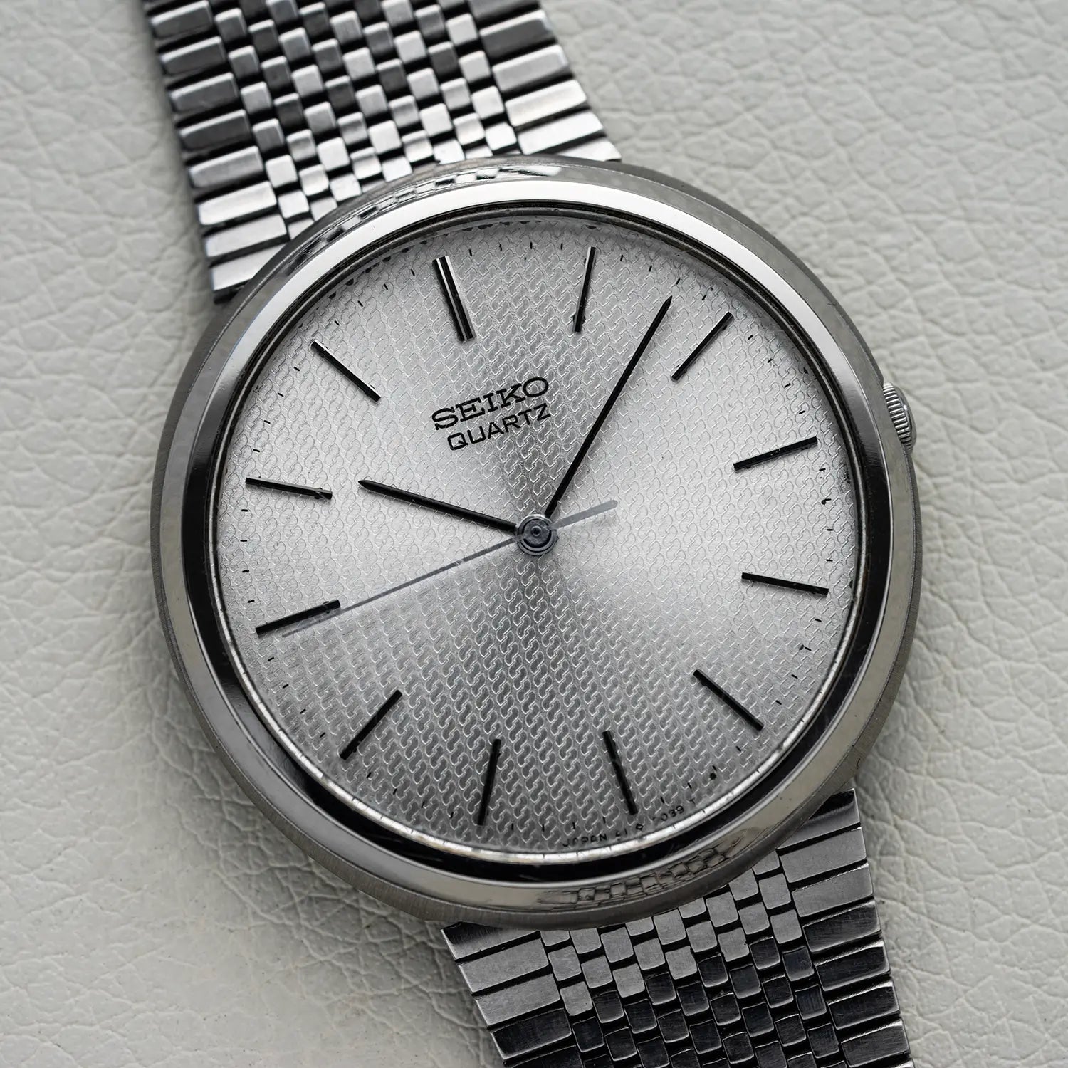 Silver Seiko Quartz 4100-9029 watch on a light gray textured background