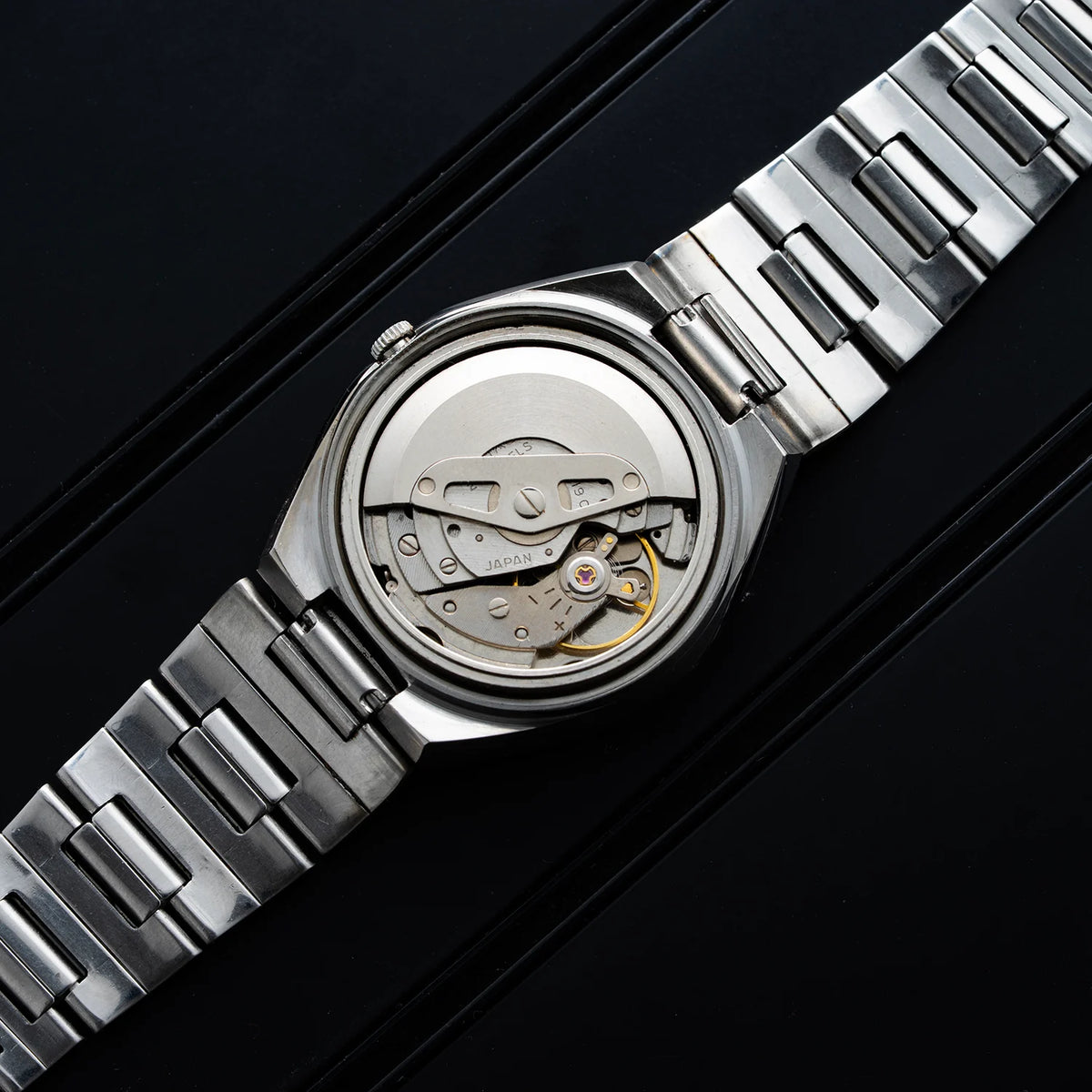 Seiko caliber 6119 automatic movement photographed inside a 1976 Seiko 5 6119-5431 with open case back and rotor visible