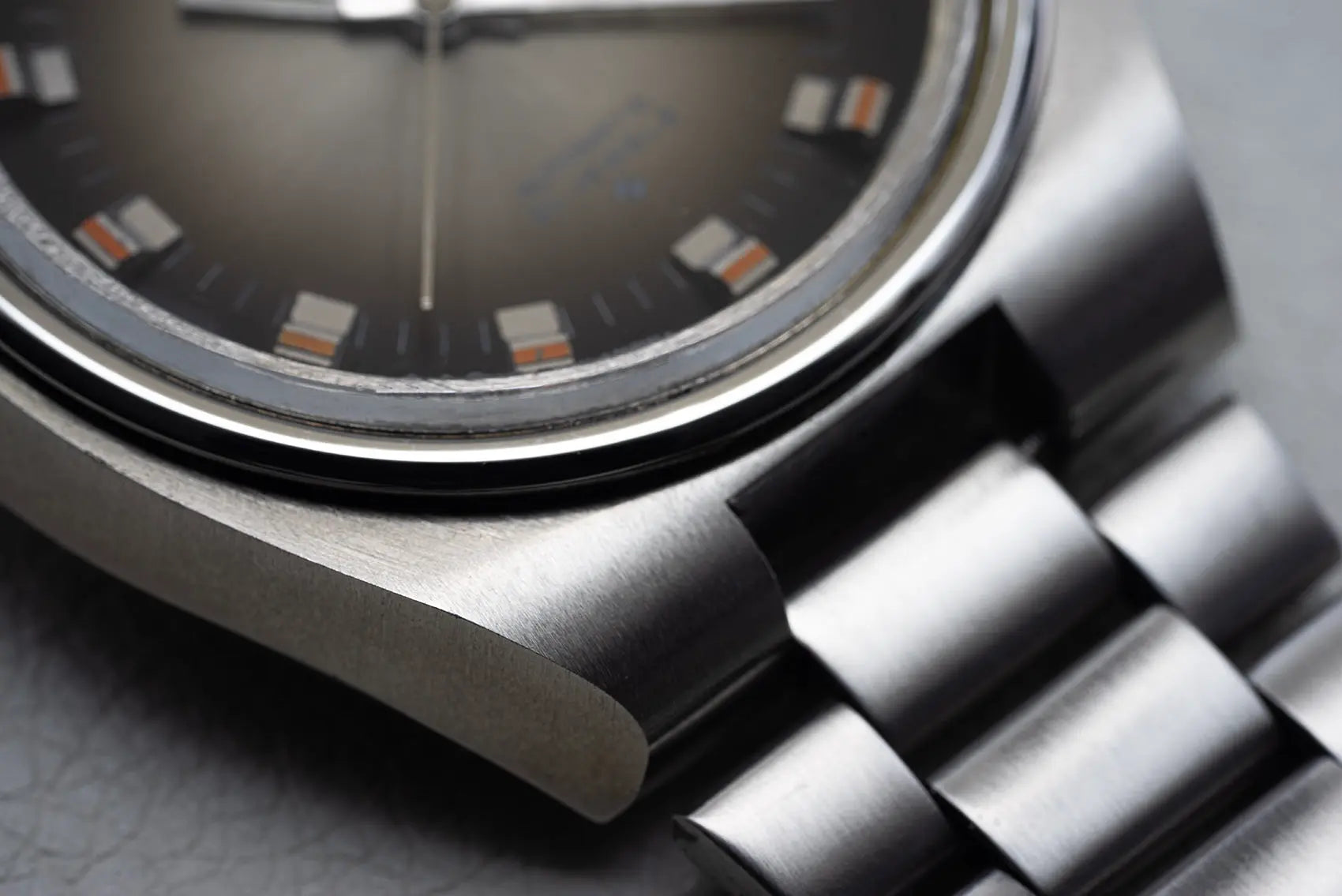 Close-up of a silver Seiko 5 6119 7540 with a detailed face on a gray background