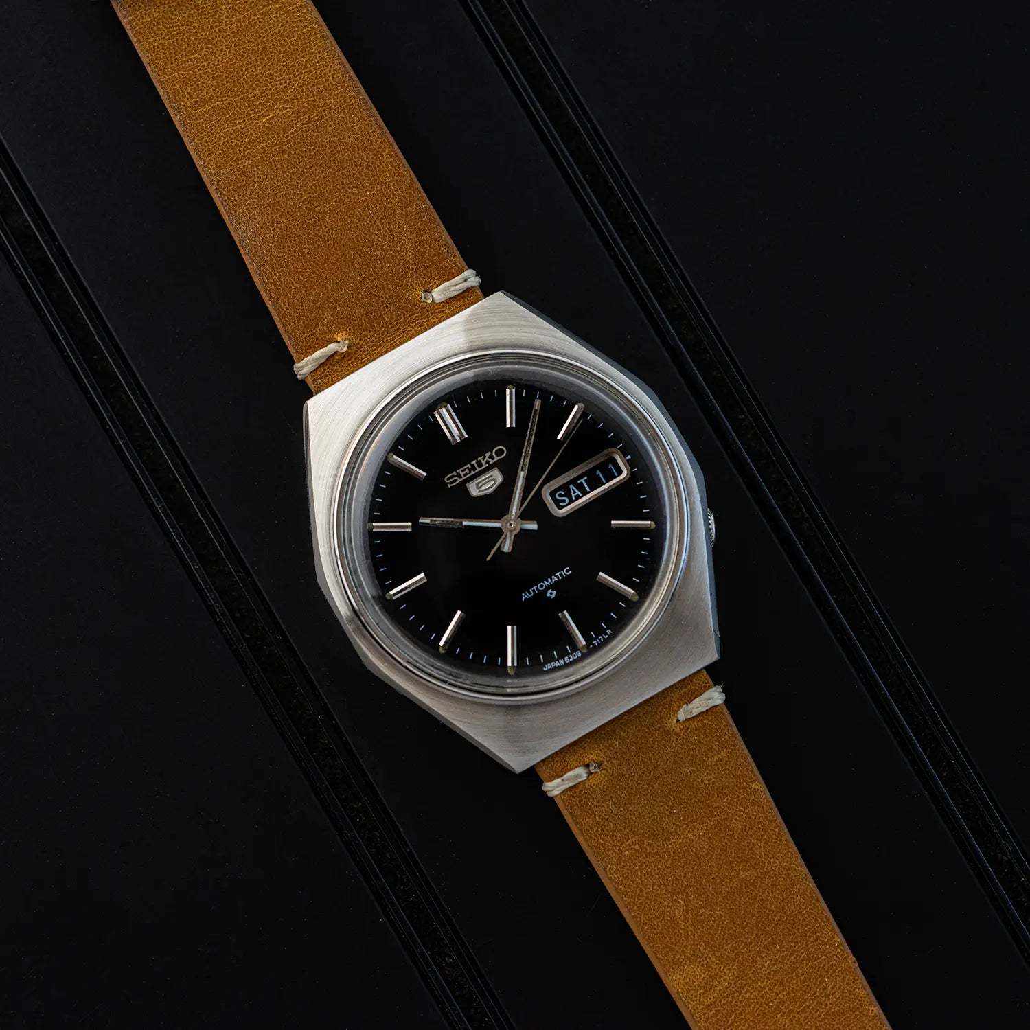 Watch Seiko 5 6309 8840 with brown leather strap and black face on a black background