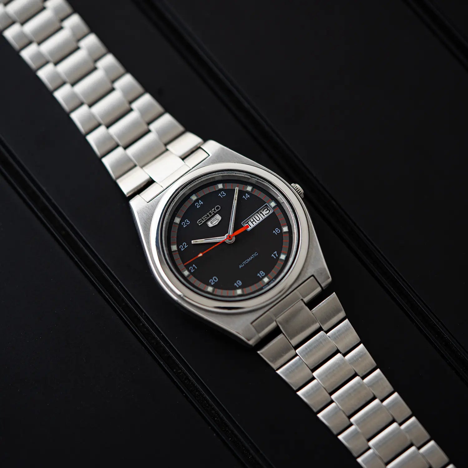 Seiko 5 6309 8980 wristwatch with a black face on a dark background
