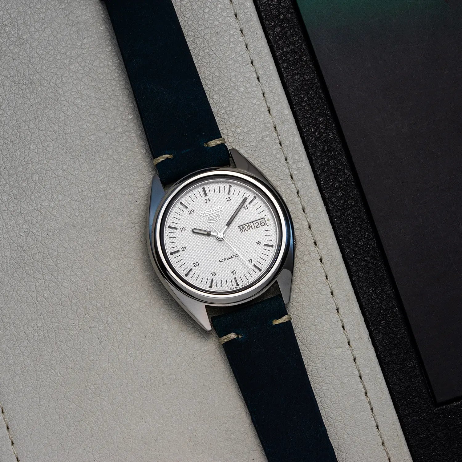 Wristwatch Seiko 5 7009 3040 with blue strap and silver case on a gray surface