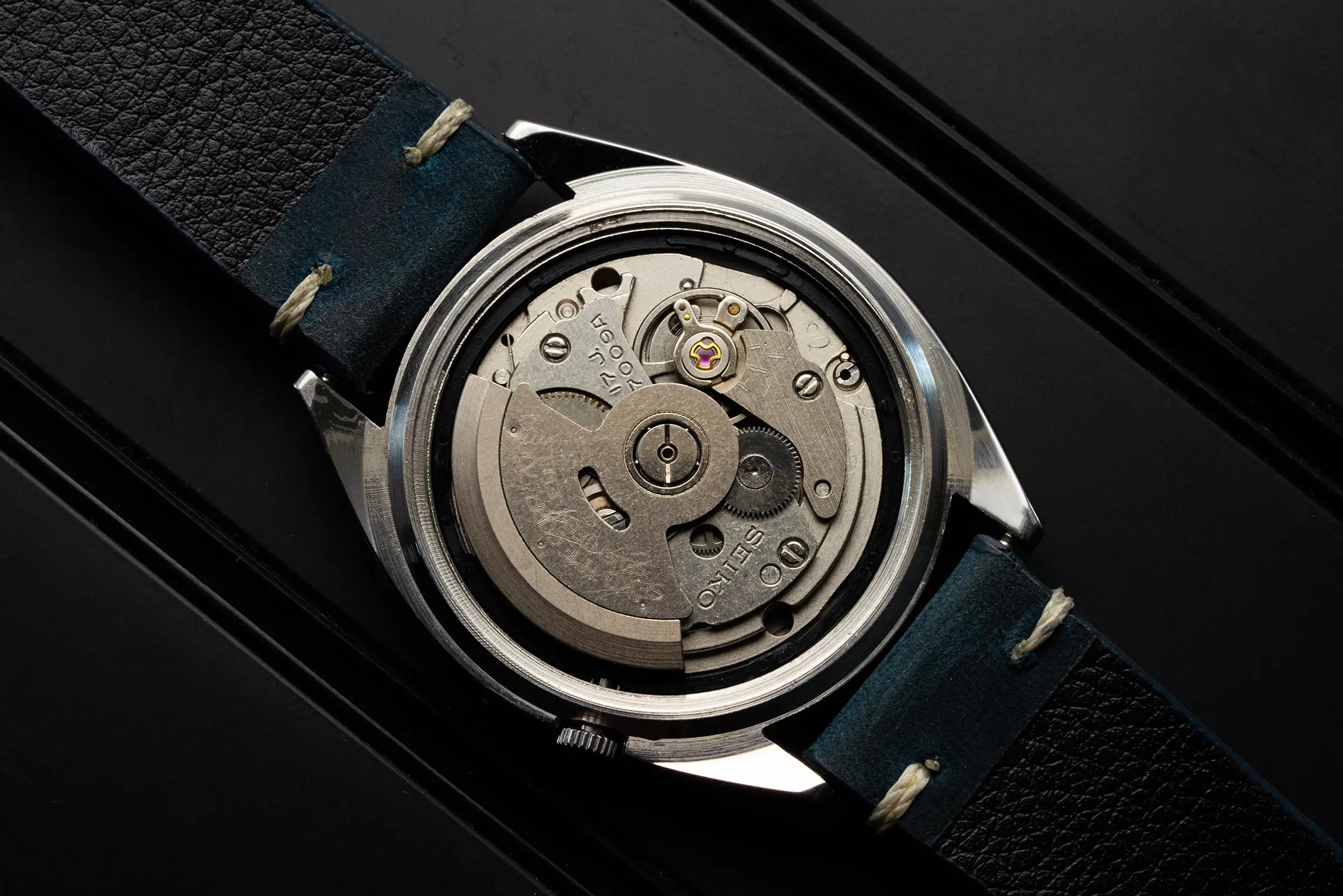 Close-up of a mechanical watch moverment Seiko 7009 with visible gears on a black background