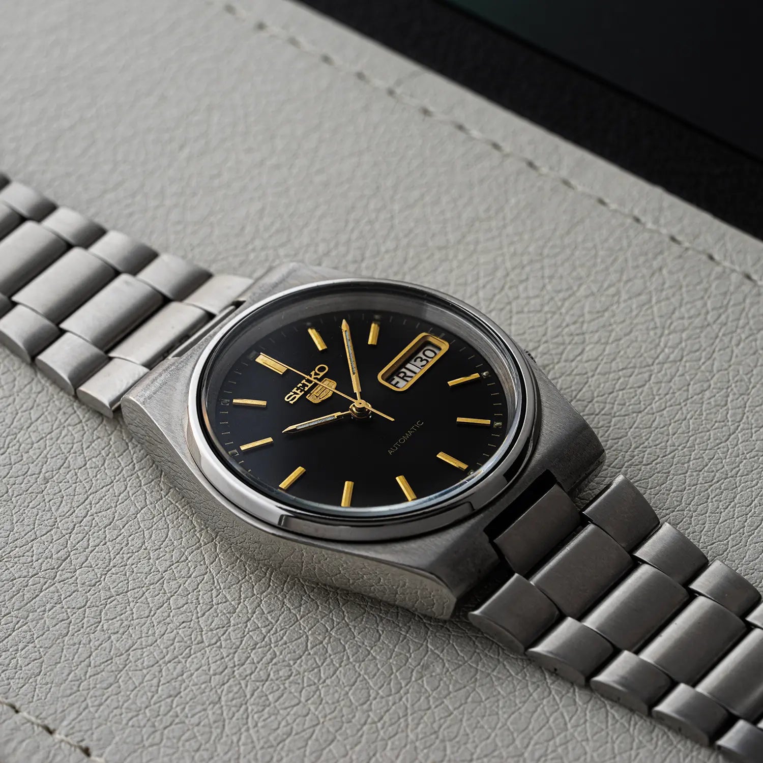 Silver Seiko 5, Ref. 7009-3130 case on a gray textured surface