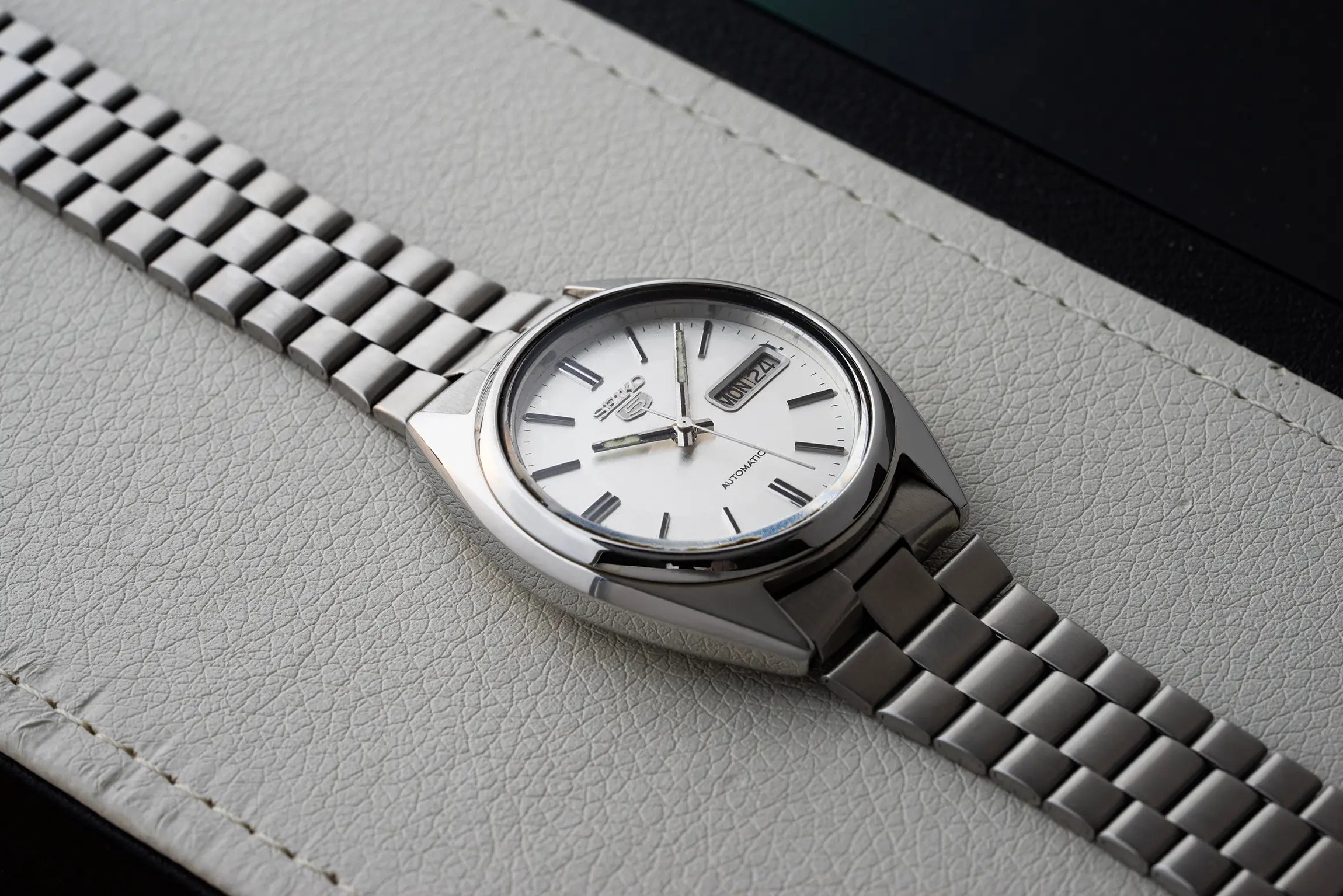 Seiko 5, Ref. 7009-8741 case with a white face on a textured gray surface