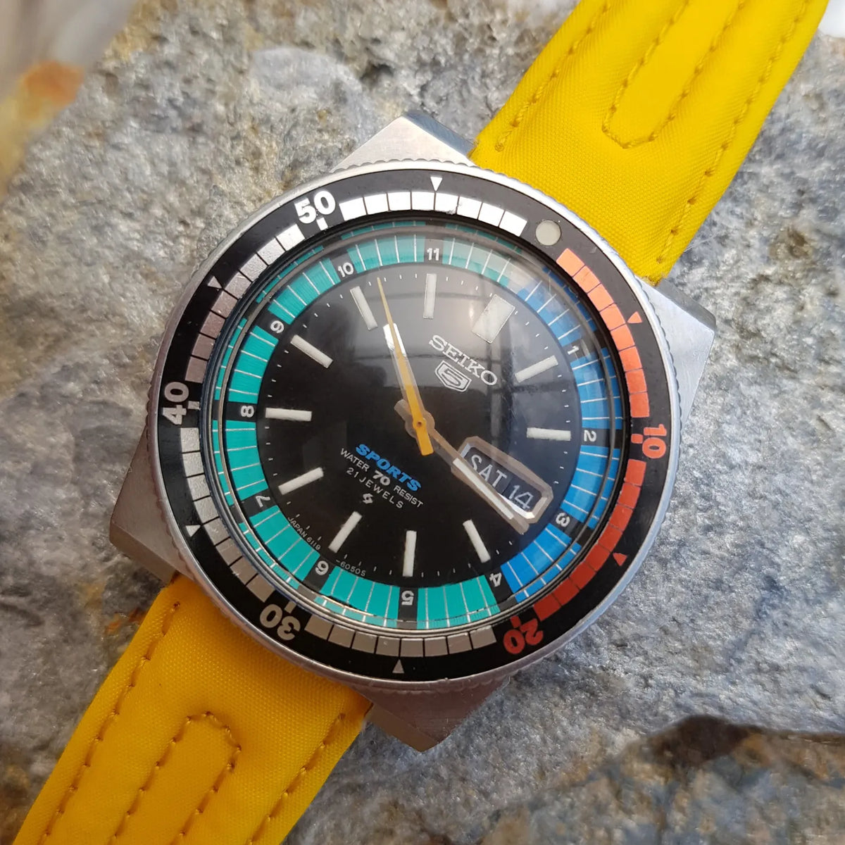Colorful 1971 Seiko 5 Sports Regatta reference 6119-6053 with a multicolor timing track, black dial and yellow strap