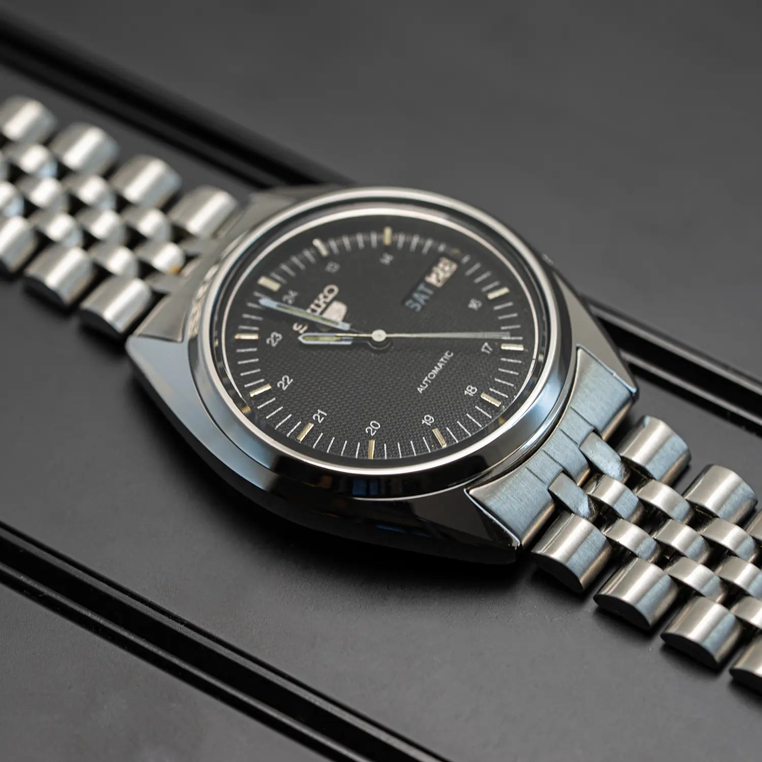 Seiko 5 7009 3040 case with black face on a dark background