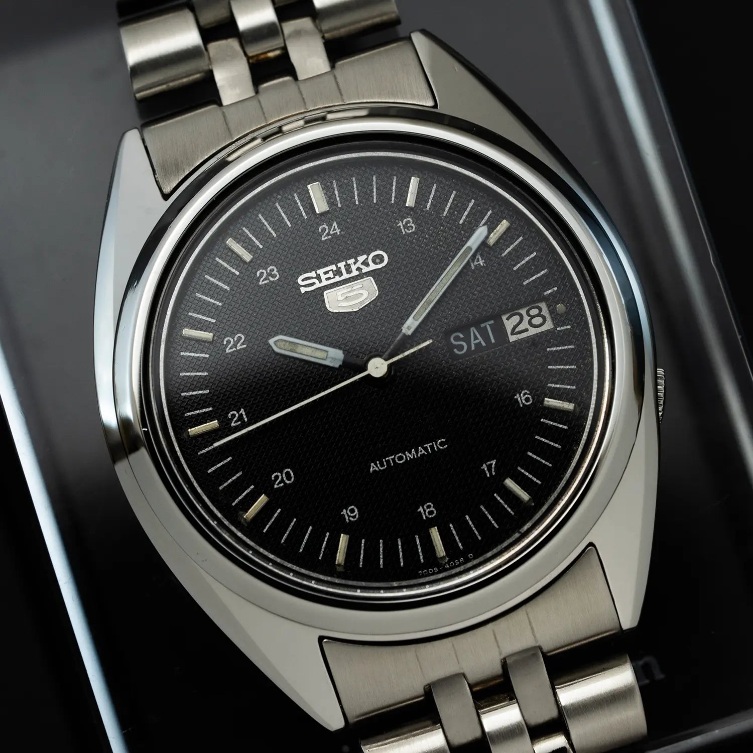Seiko 5 7009 3040 watch with black dial on a dark background