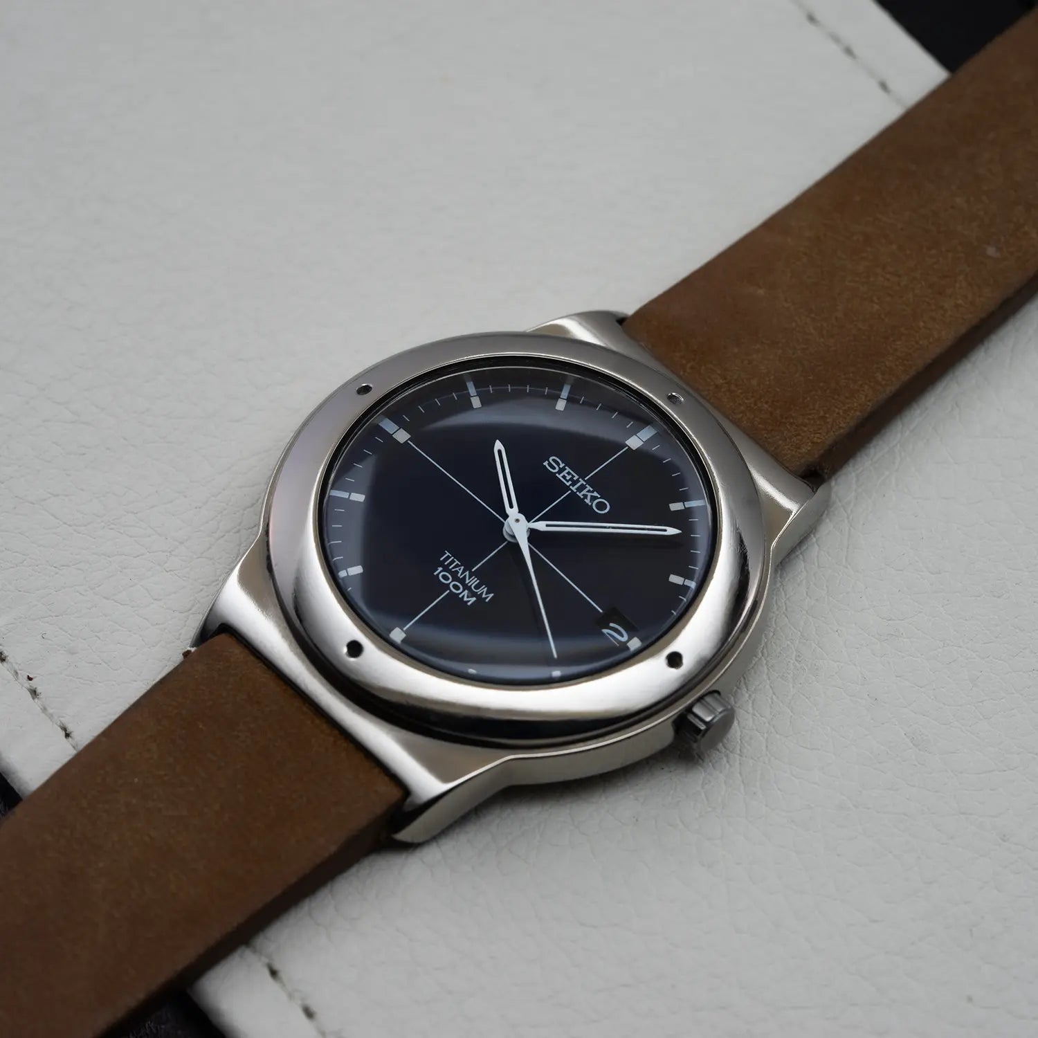 Seiko 7N42-0CB0 crown with brown strap on a light gray background