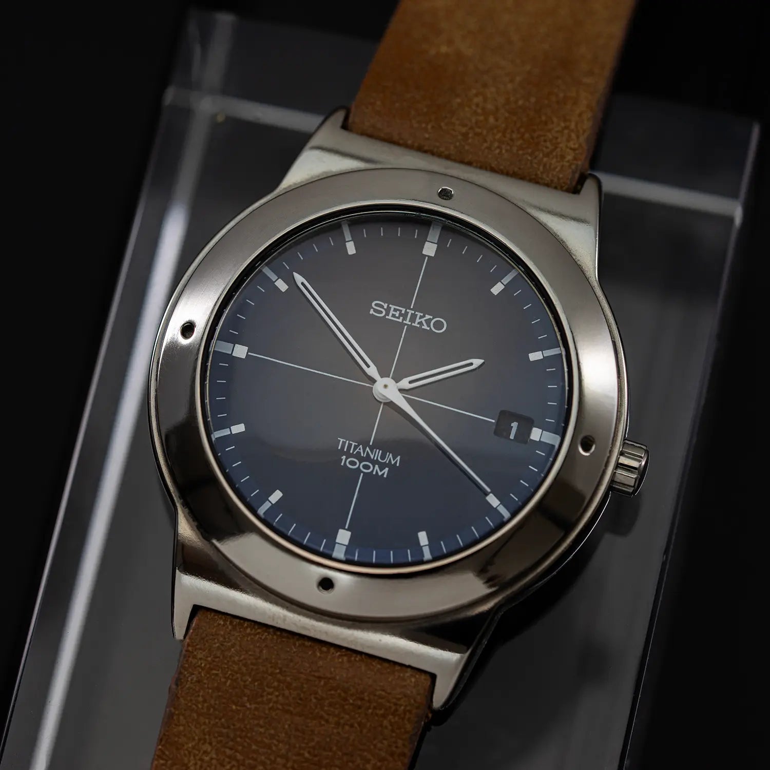 Seiko 7N42-0CB0 watch with brown leather strap on a reflective surface