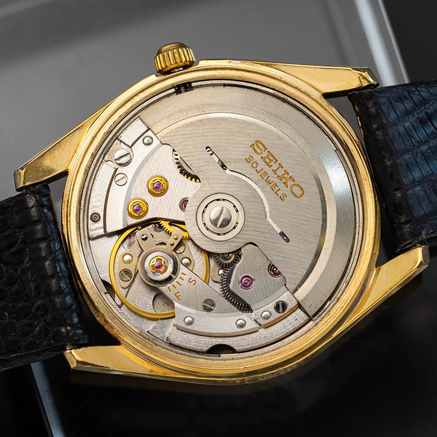Close-up of a Seiko movenet 8035  with casing and black leather strap.
