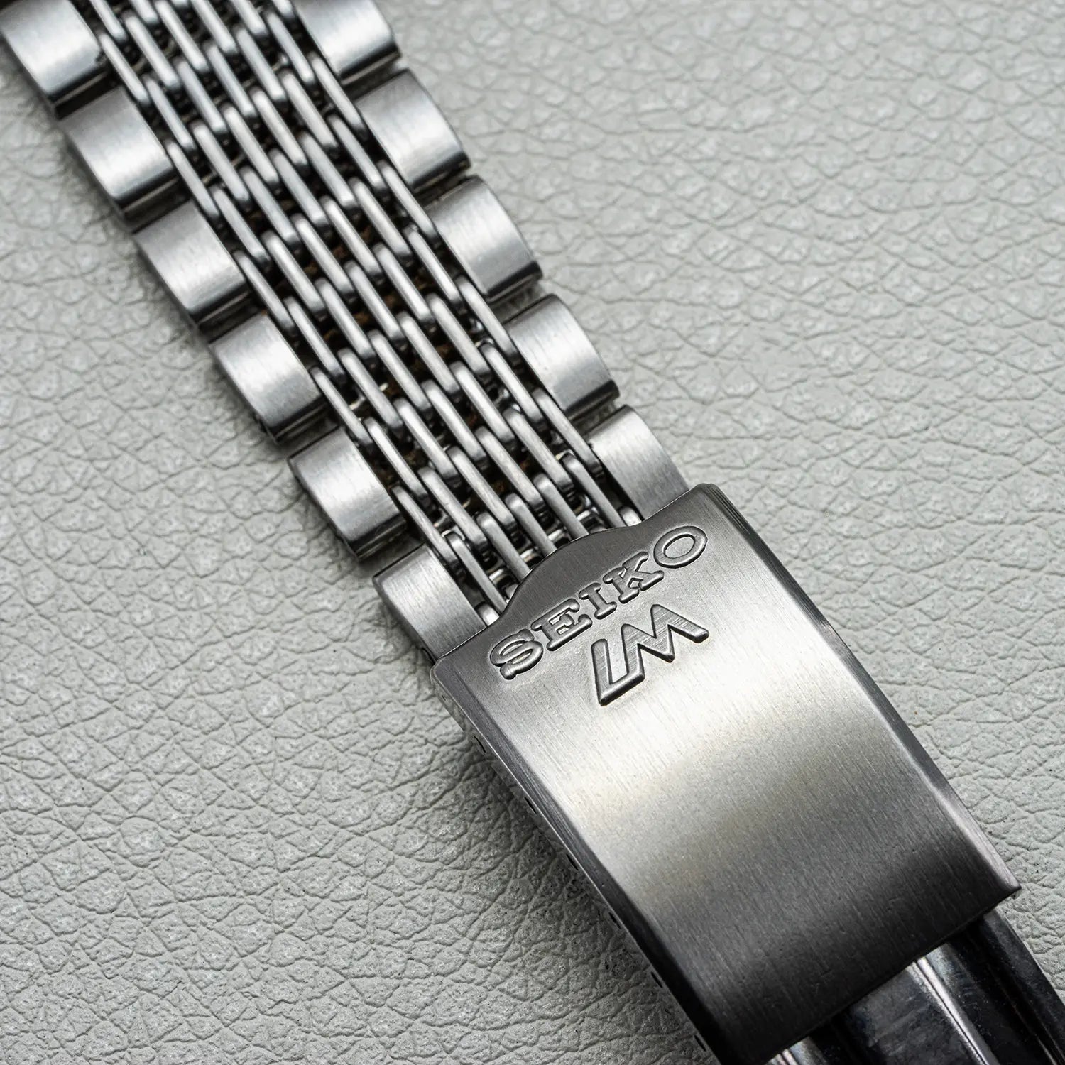 Close-up of aSeiko LM 5606-7071 Bracelet on a textured gray background