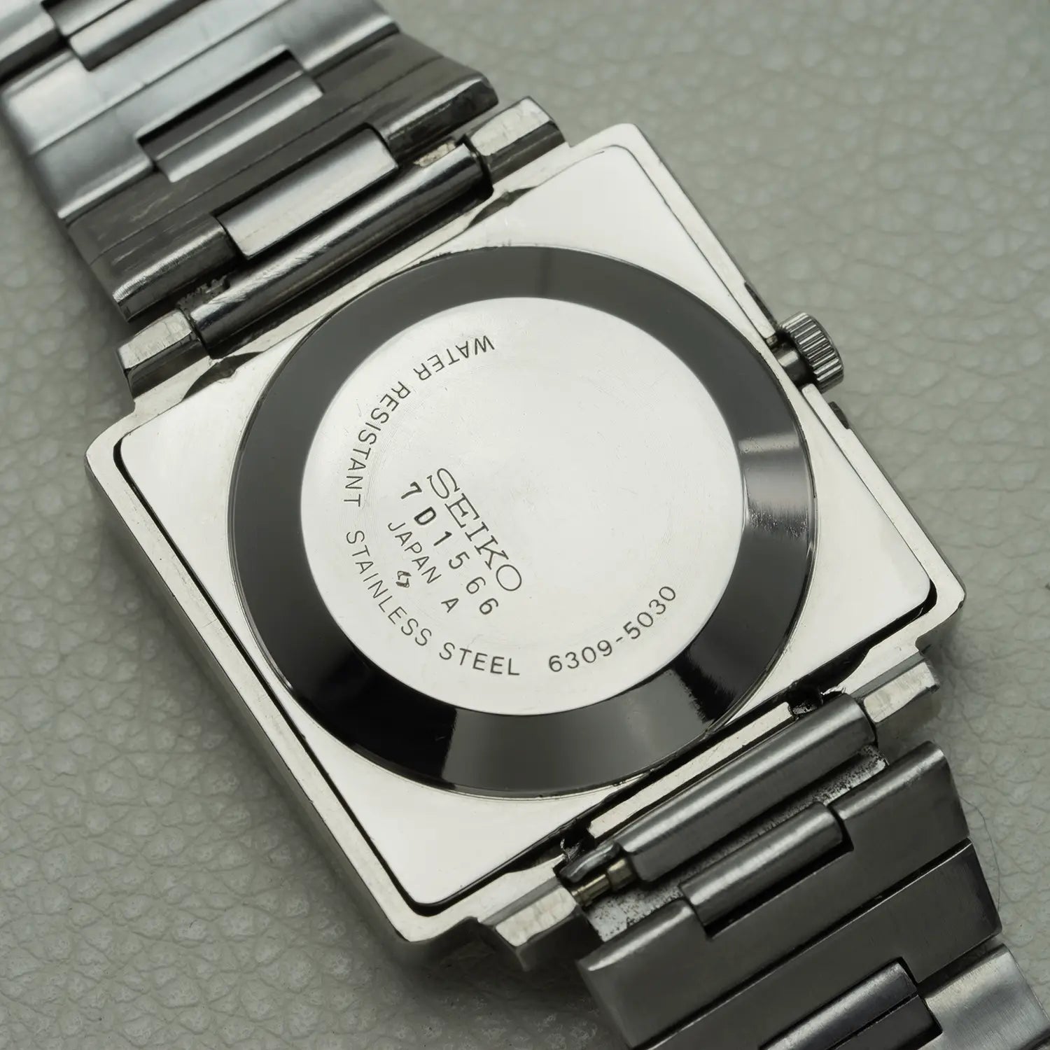 Close-up of a Seiko TV Screen Ref. 6309-5030 watch back cover on a textured gray background