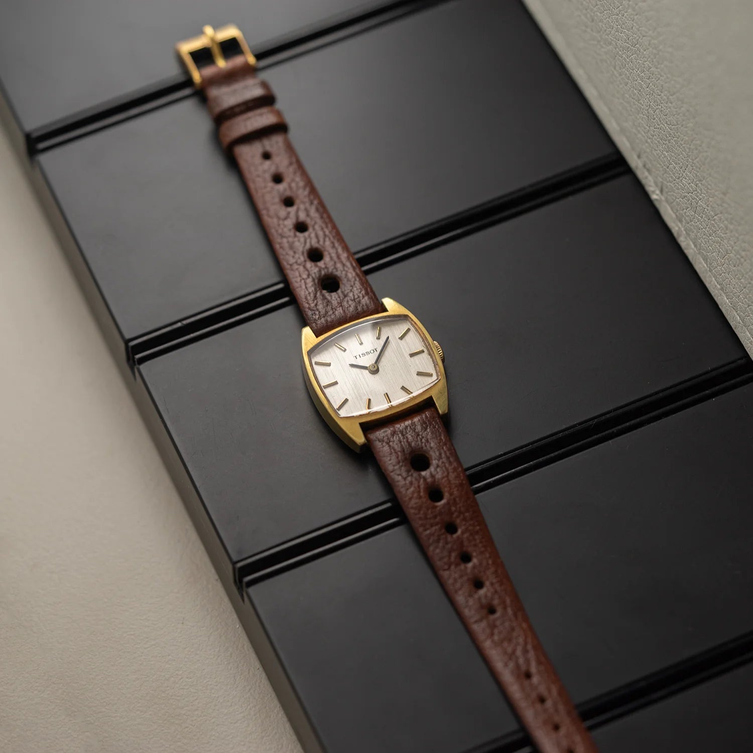Tissot vintage women’s watch from 1978 on brown leather strap with gold plated tonneau case, angled full-watch view
