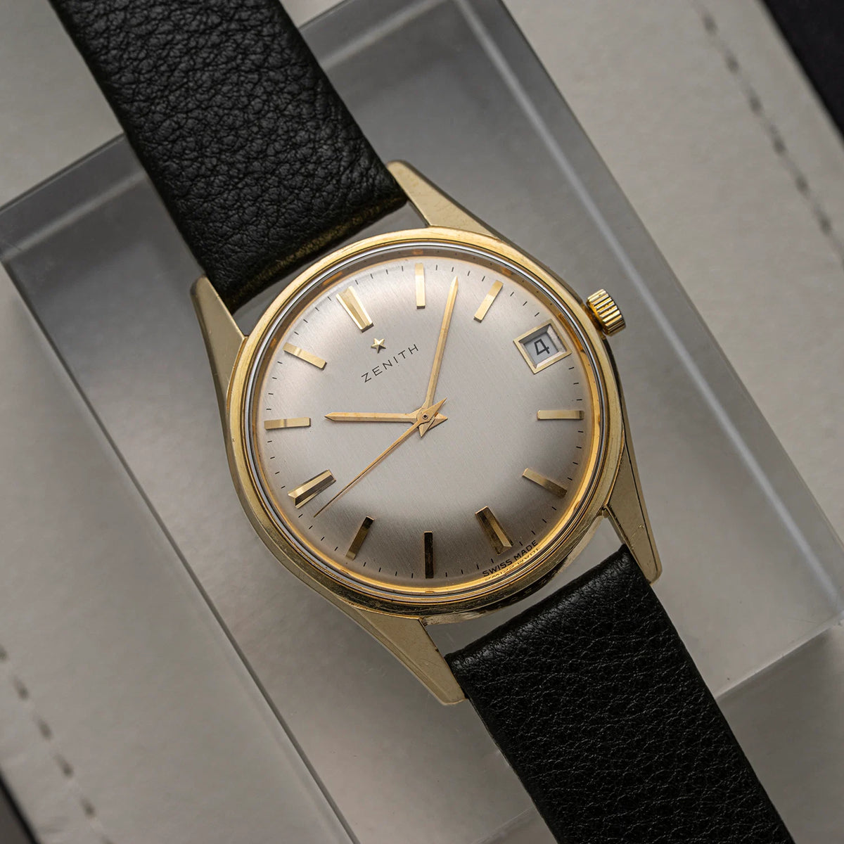 Zenith Zenith, Cal. 2532C, Men’s Manual Wind Vintage Watch, 1966 with black strap and gold casing on a gray background