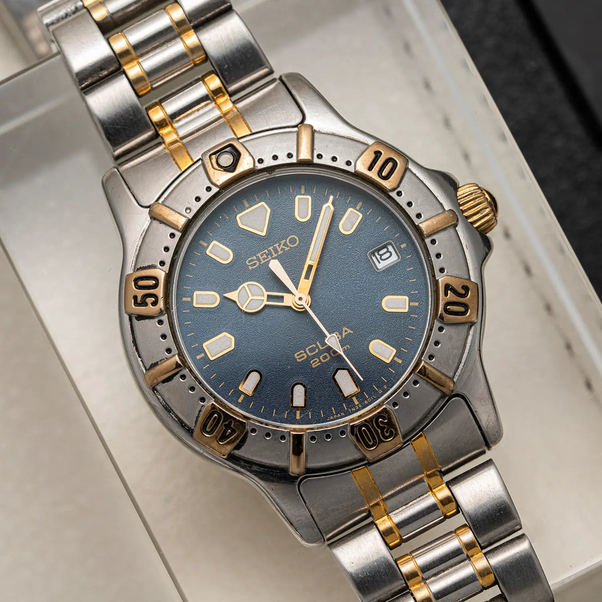 A Seiko Scuba 200M, Ref. 7N35-6020, Cal. 7N35, Diving, 1992 diver watch with a two-tone silver and gold stainless steel bracelet, featuring a blue dial and a matching blue bezel with gold accents.