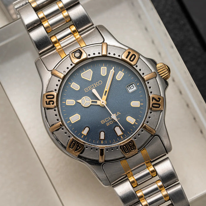 A Seiko Scuba 200M, Ref. 7N35-6020, Cal. 7N35, Diving, 1992 diver watch with a two-tone silver and gold stainless steel bracelet, featuring a blue dial and a matching blue bezel with gold accents.